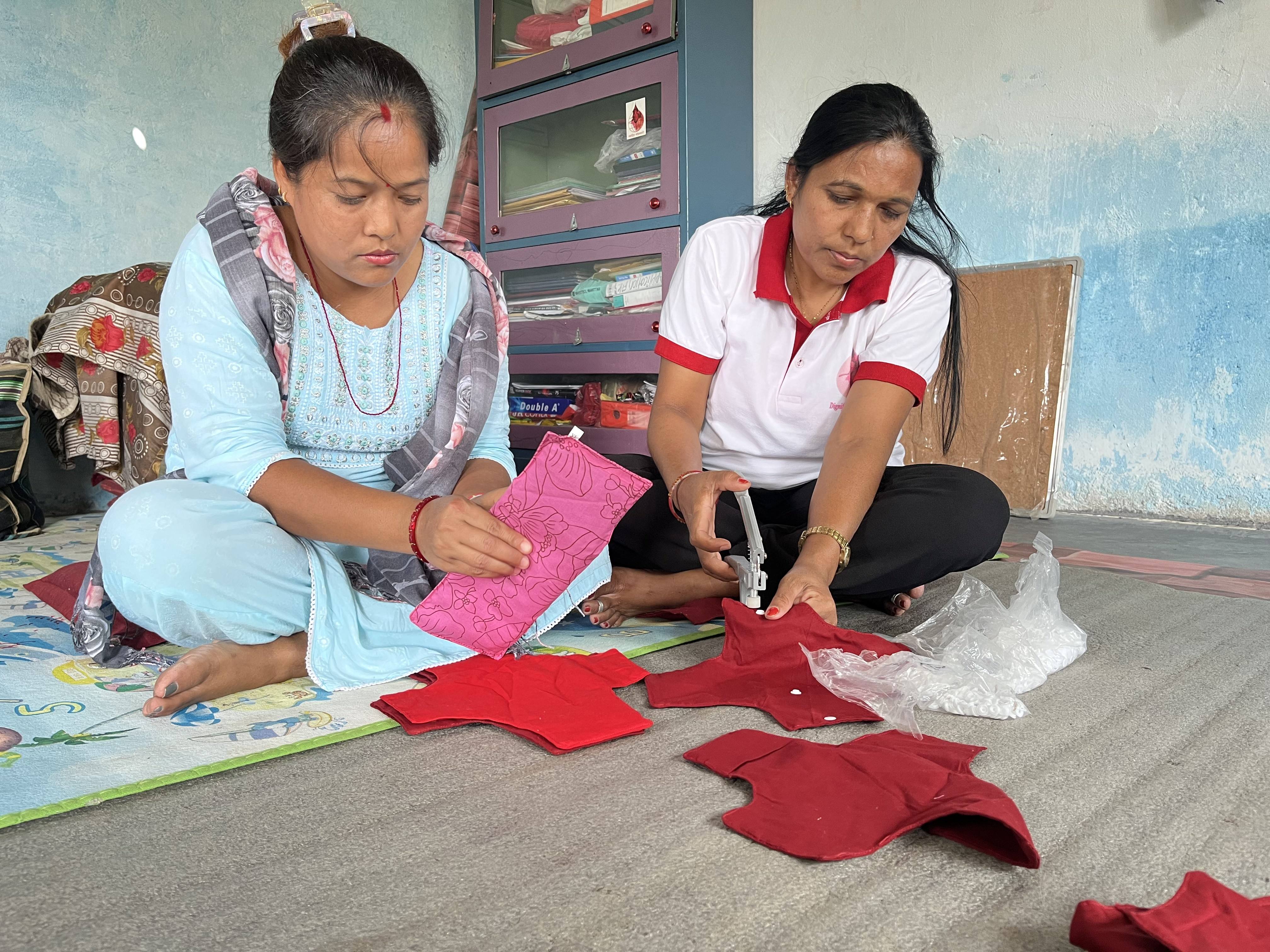 Anjana Kumal (left) and Maya Devi Sunar putting final touches on reusable cloth pad at the Miteri Jaibik Pad Udhyog factory in Chitwan. Photo: Bibek Bhandari