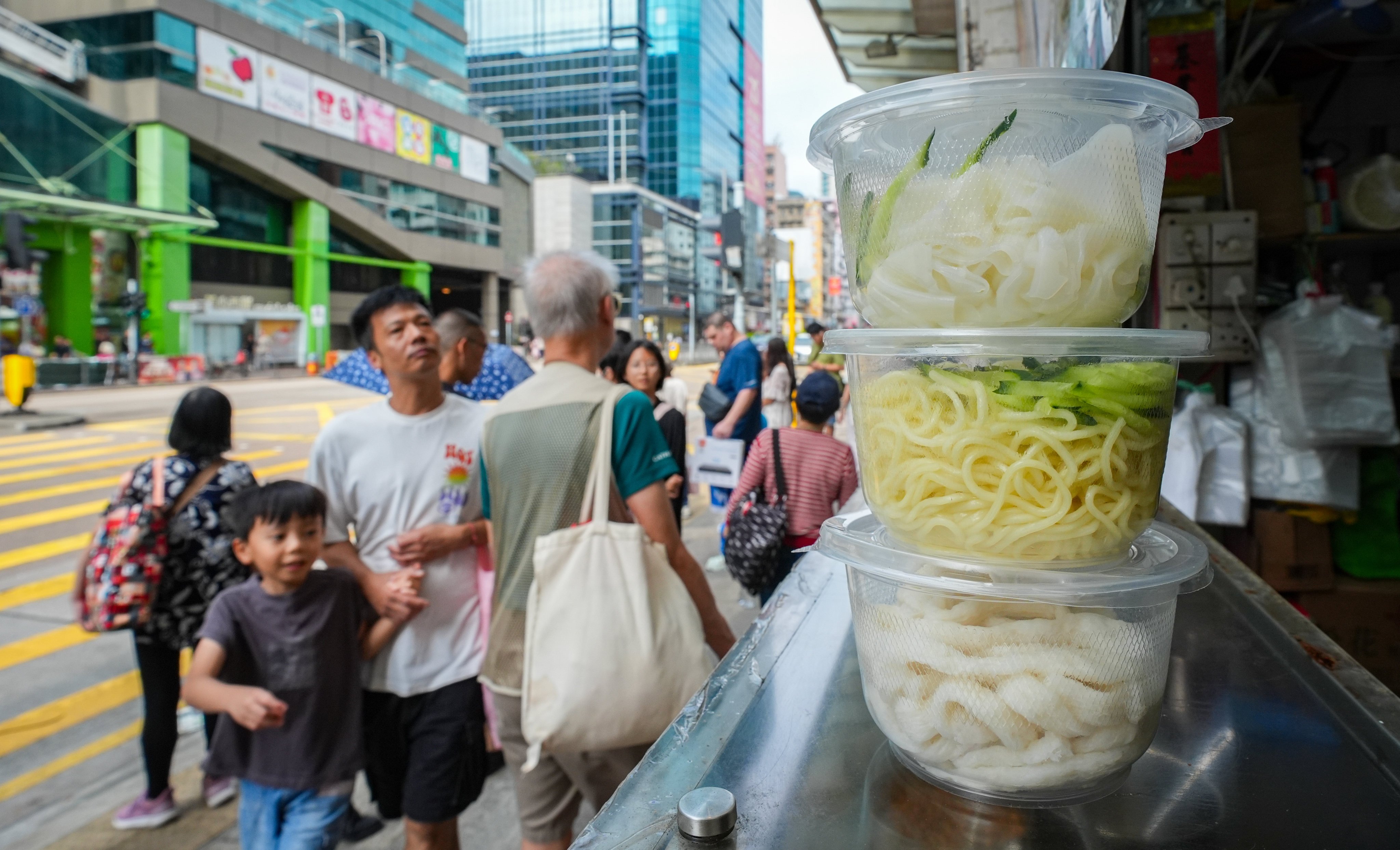 Pedestrians walk by a shop in Sham Shui Po using single-use plastics, on October 20, 2024. Photo: Eugene Lee
