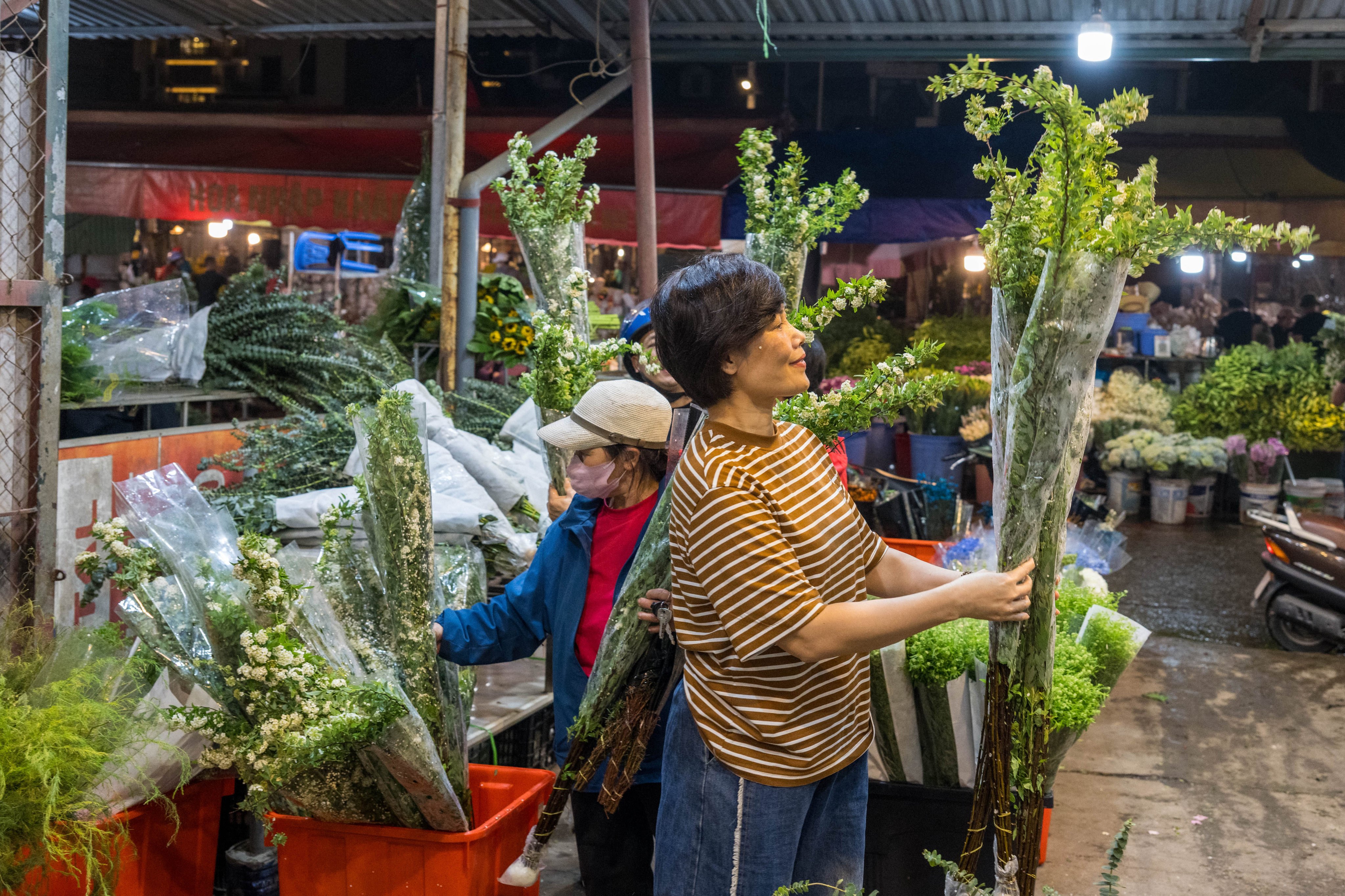 A woman buys flowers from Yunnan province at Hanoi’s  Quang Ba Flower Market on March 28. Photo: Xinhua