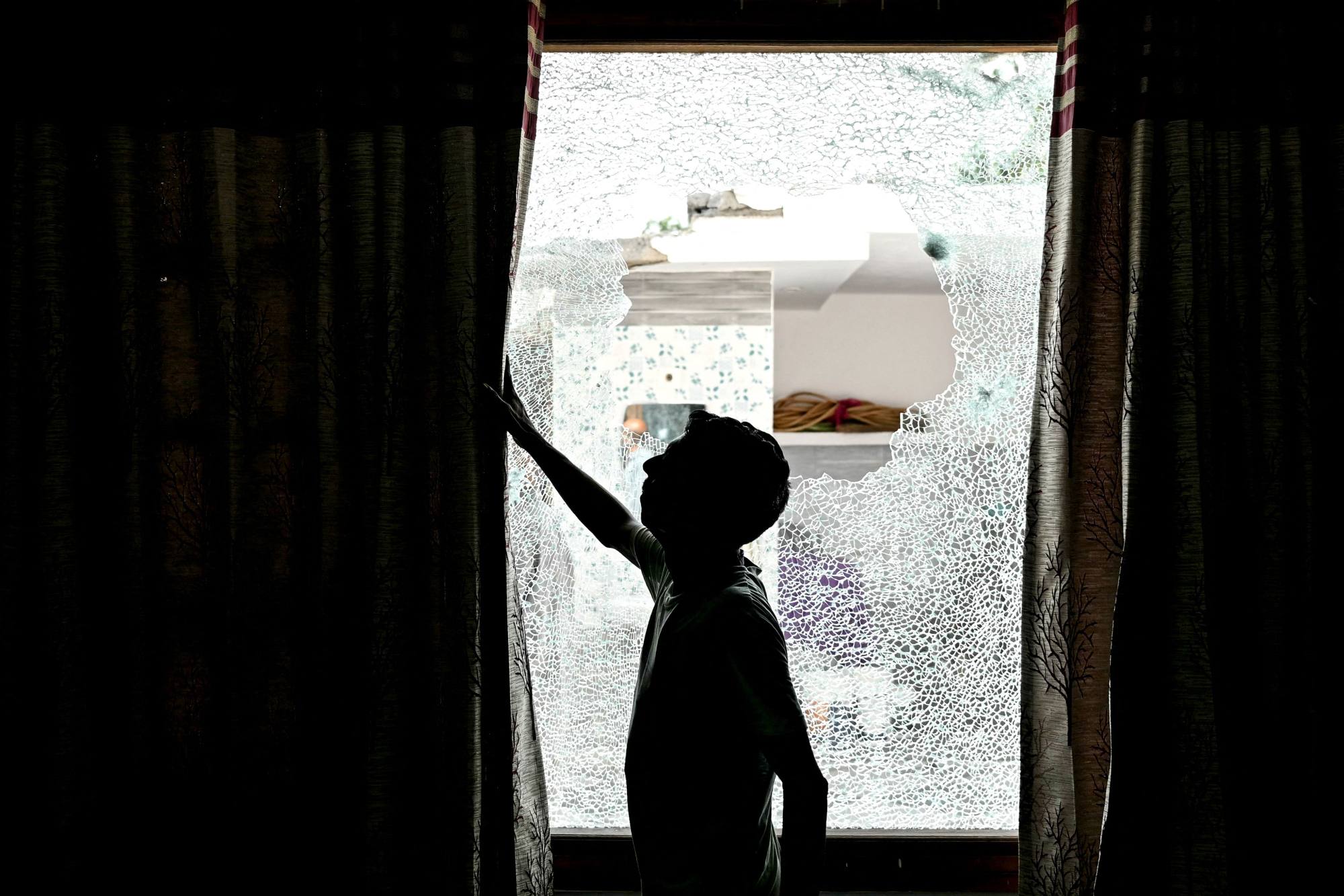 A man shows the shattered window of a house after cross-border shelling in India’s Jammu region on Saturday. Photo: AFP A man shows the shattered window of a house after cross-border shelling in India’s Jammu region on Saturday. Photo: AFP