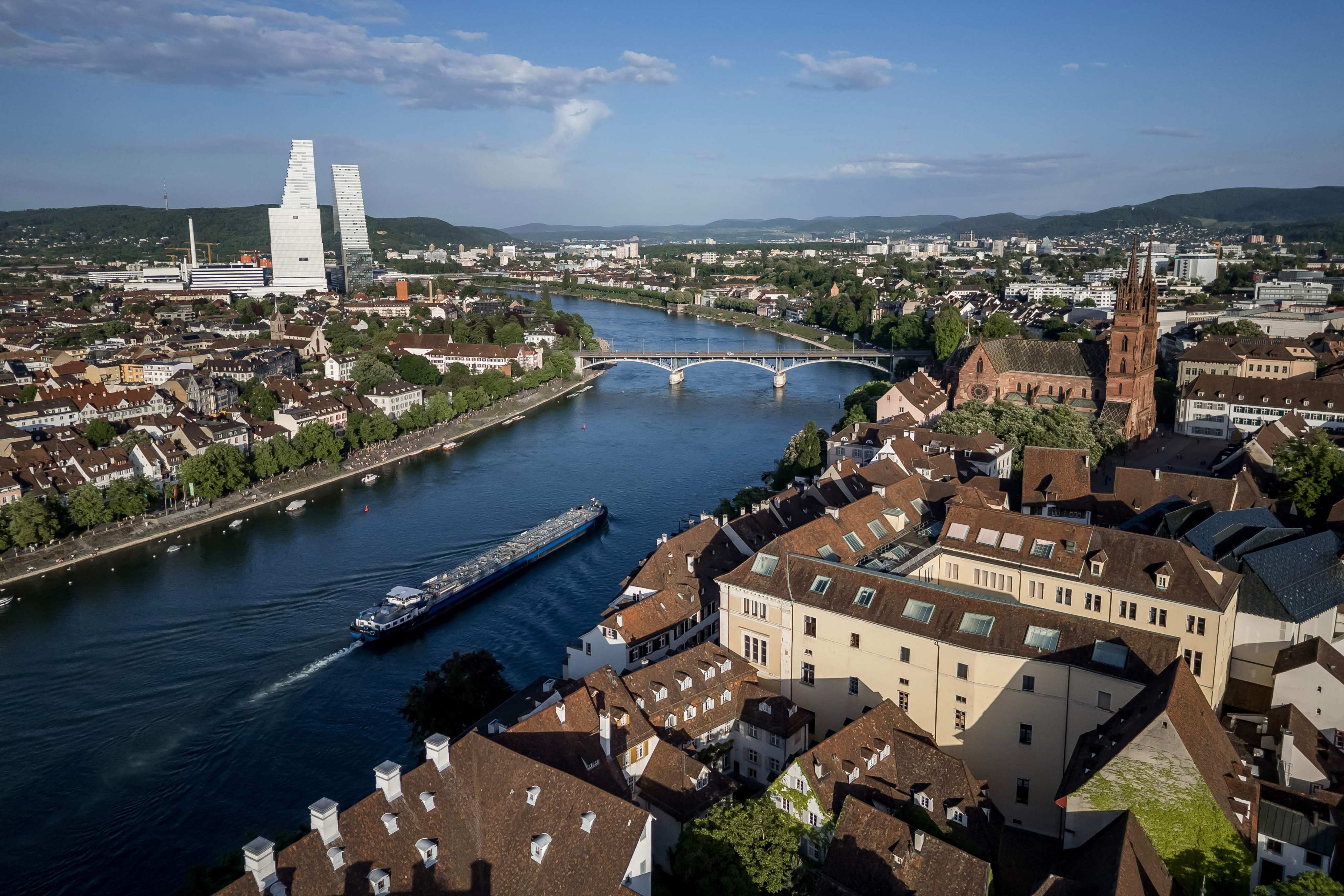 A barge sailing on tht River Rhine with the towers housing the headquarters of Swiss pharma giant Roche and the cathedral (right) in Basel. Photo: AFP