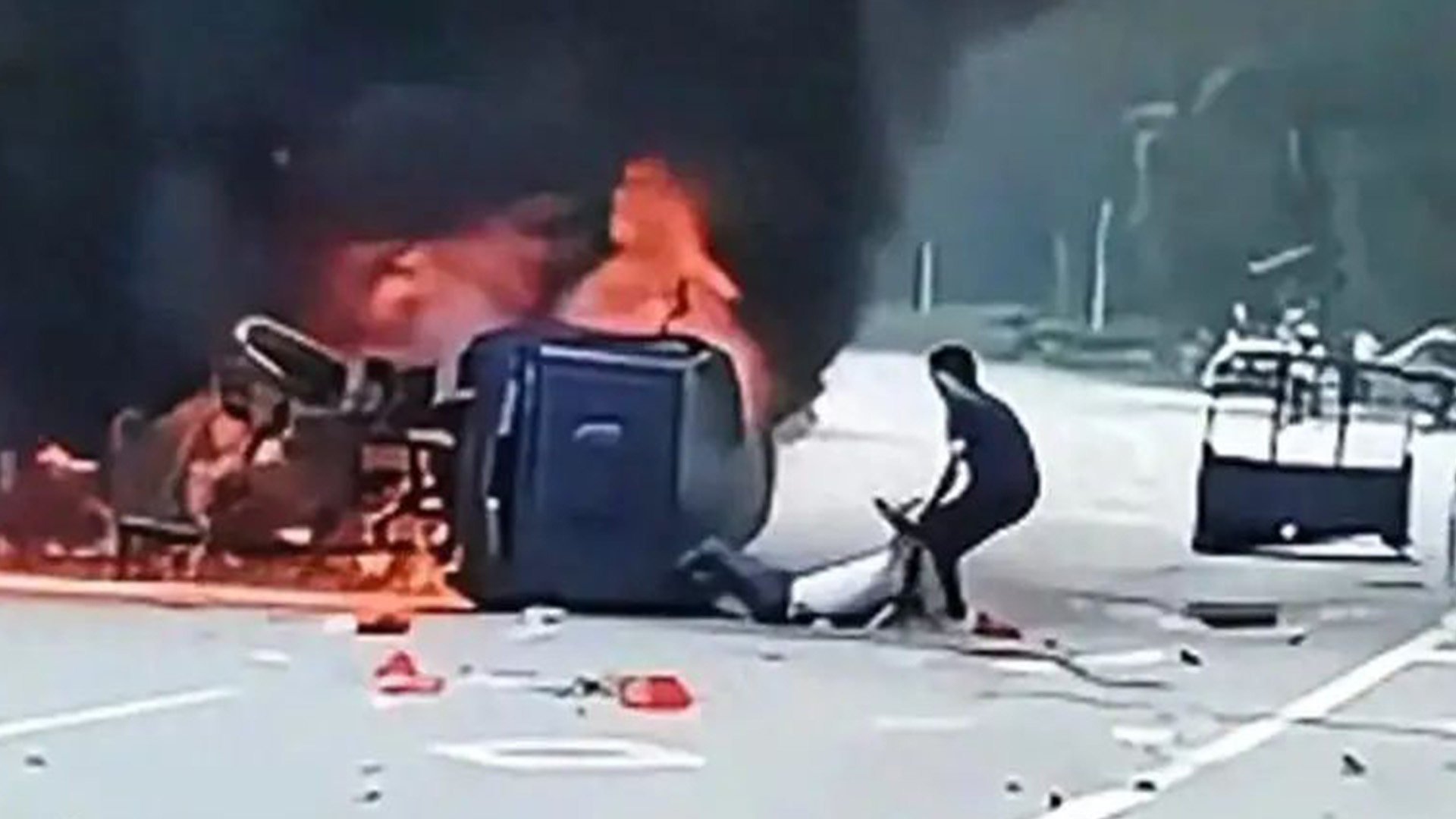 A brave Chinese man forced open the door of a blazing car with his bare hands to save its injured driver moments before the vehicle exploded. Photo: Sohu