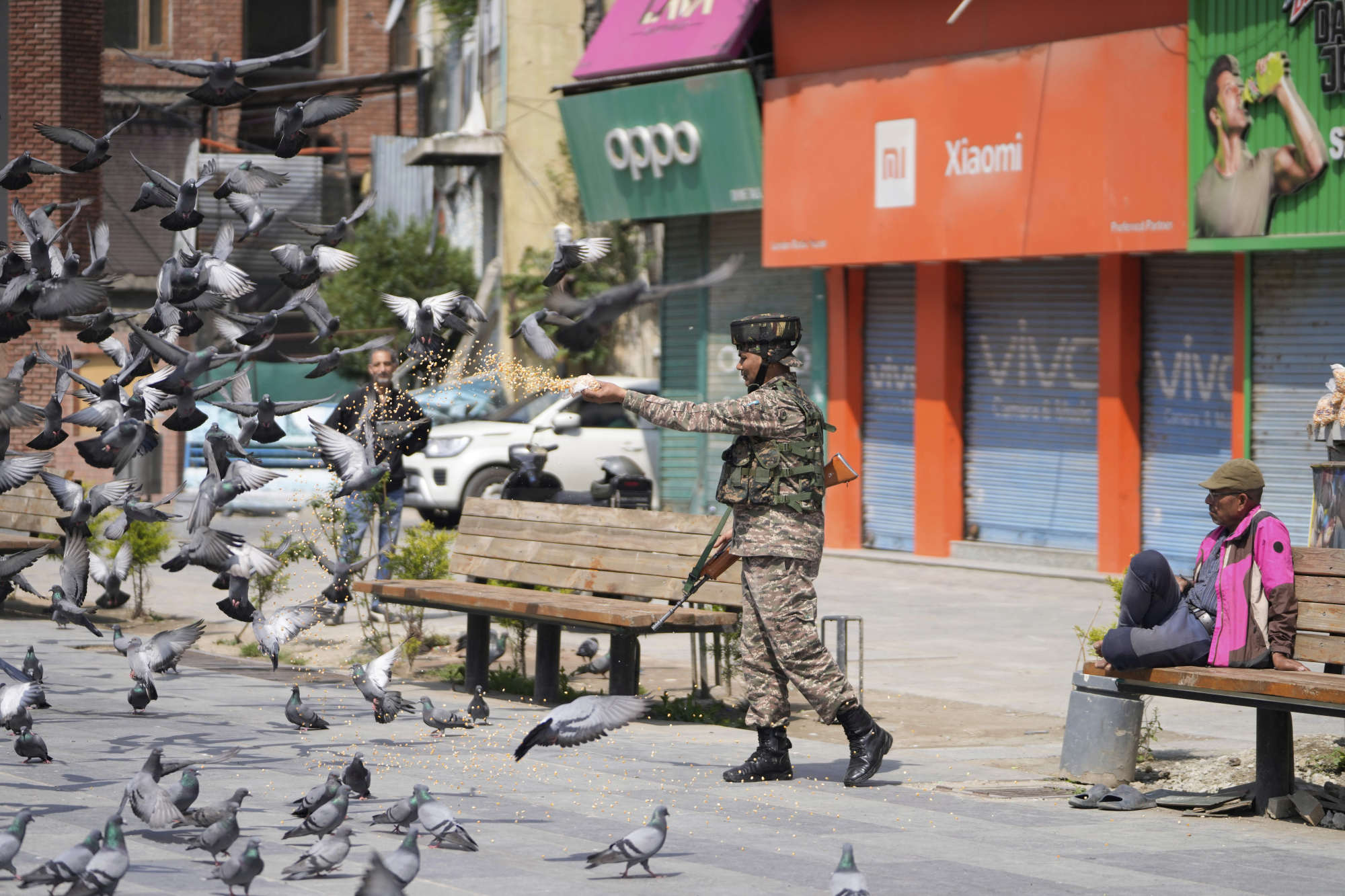 A soldier feeds pigeons at a market in Srinagar, Indian-controlled Kashmir, on Sunday. Photo: AP A soldier feeds pigeons at a market in Srinagar, Indian-controlled Kashmir, on Sunday. Photo: AP