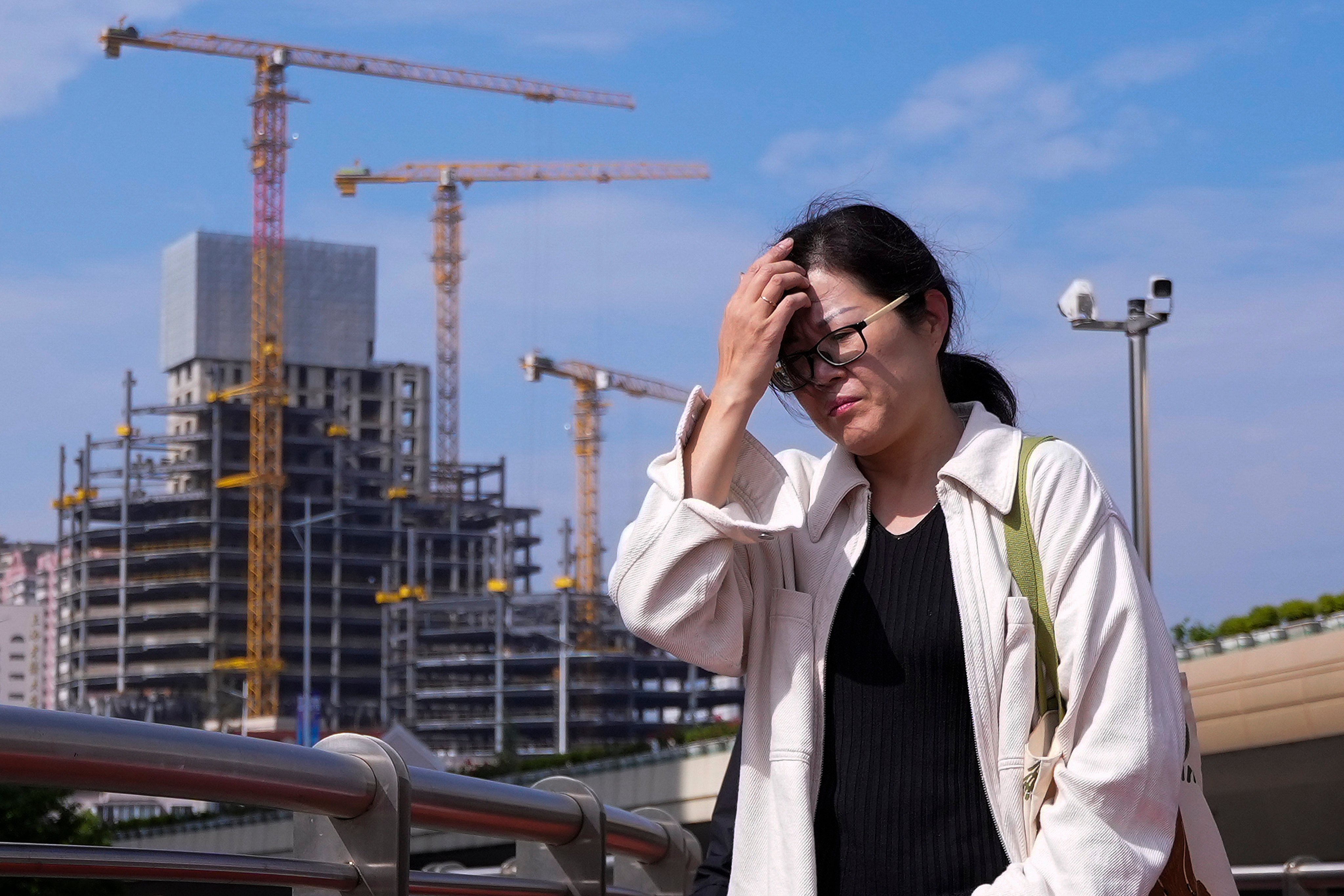 A woman passes a construction project in Shanghai. Photo: AP
