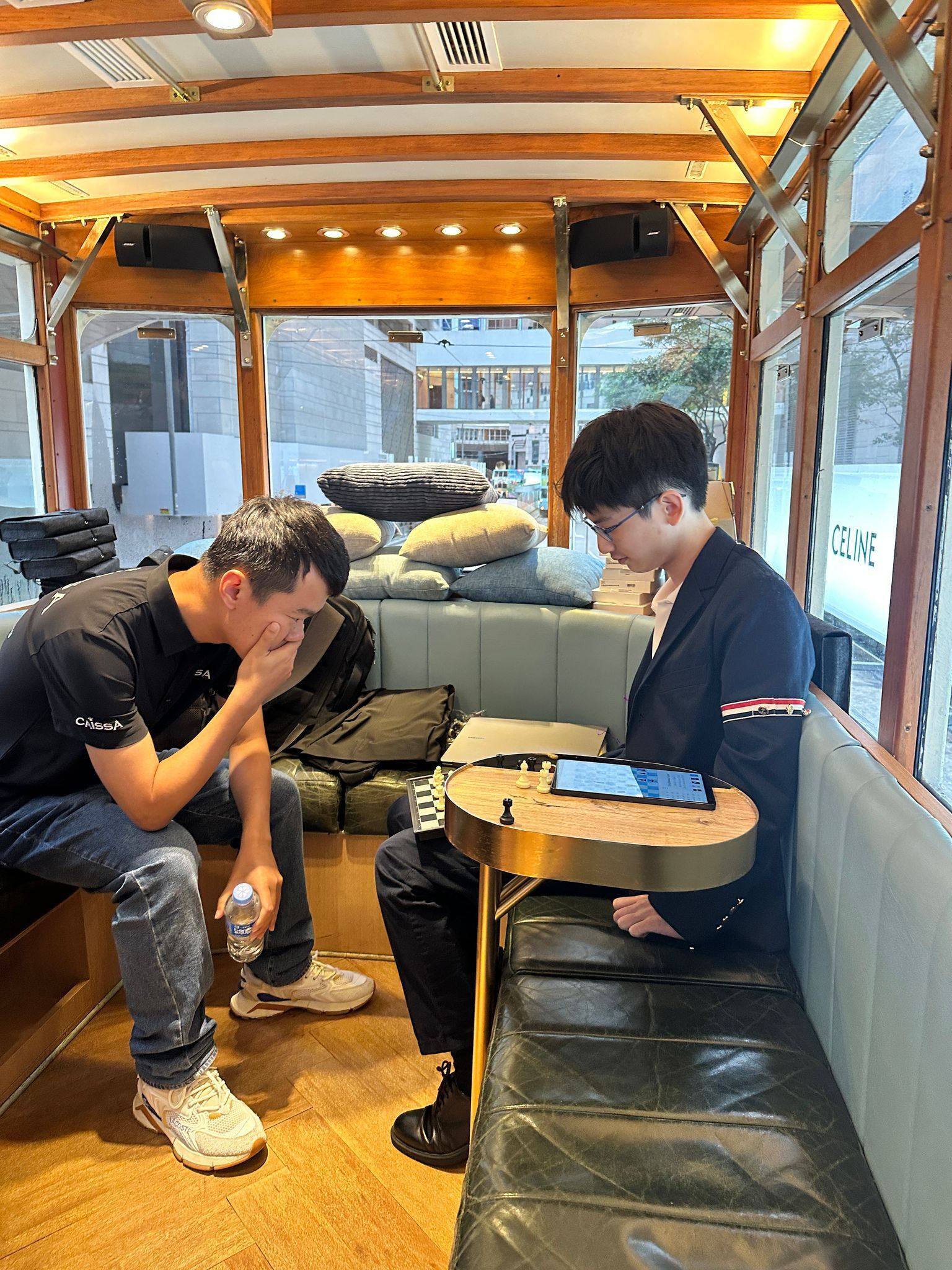 Chinese grandmaster Ding Liren (left) playing against Hong Kong No 1 Jamison Kao and 11 others on a tram. Photo: Hong Kong, China Chess Federation
