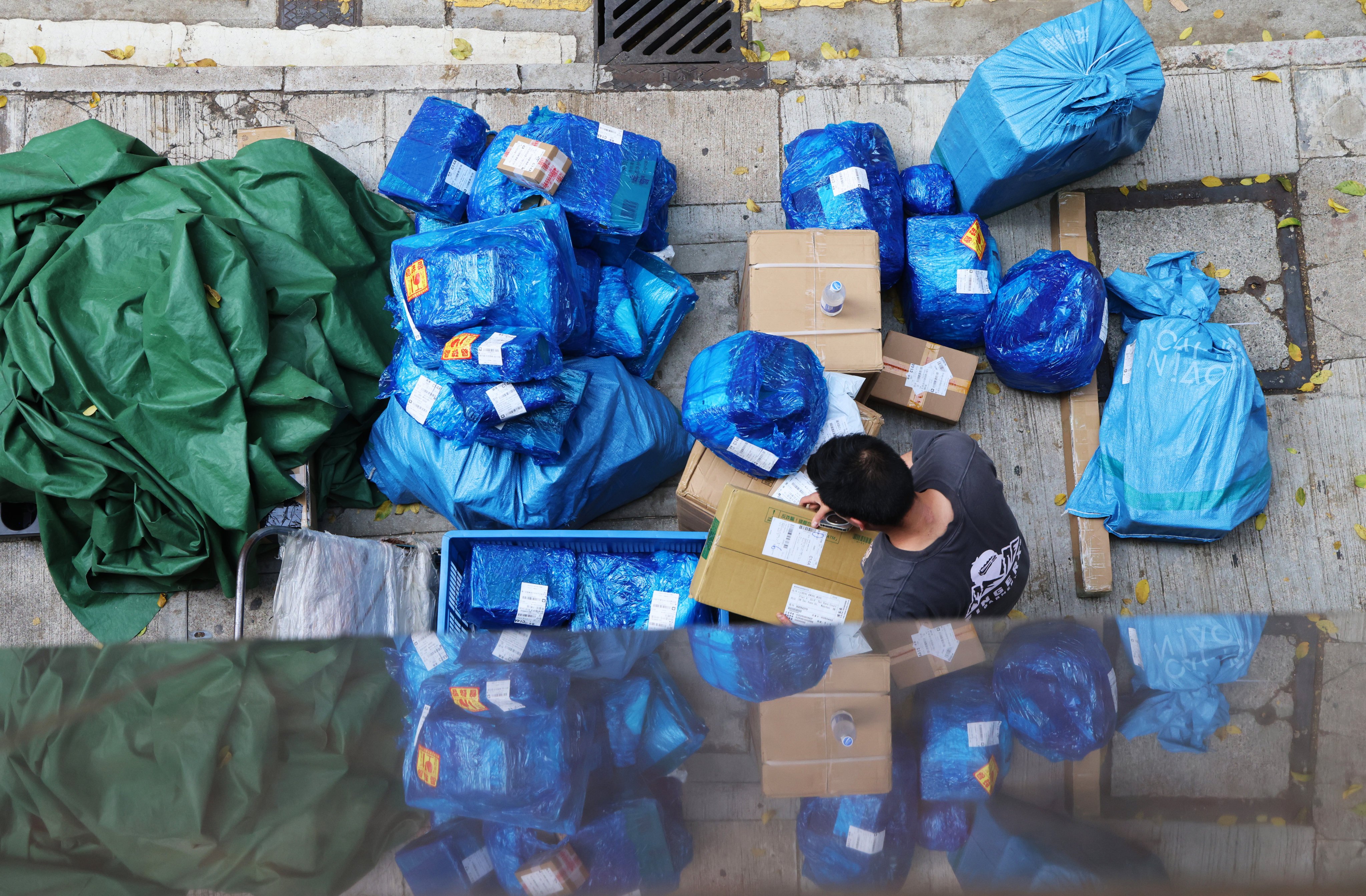 A courier worker handles parcels in Wan Chai. The US has lowered tariffs on small parcels from mainland China and Hong Kong from 120 to 54 per cent. Jelly Tse