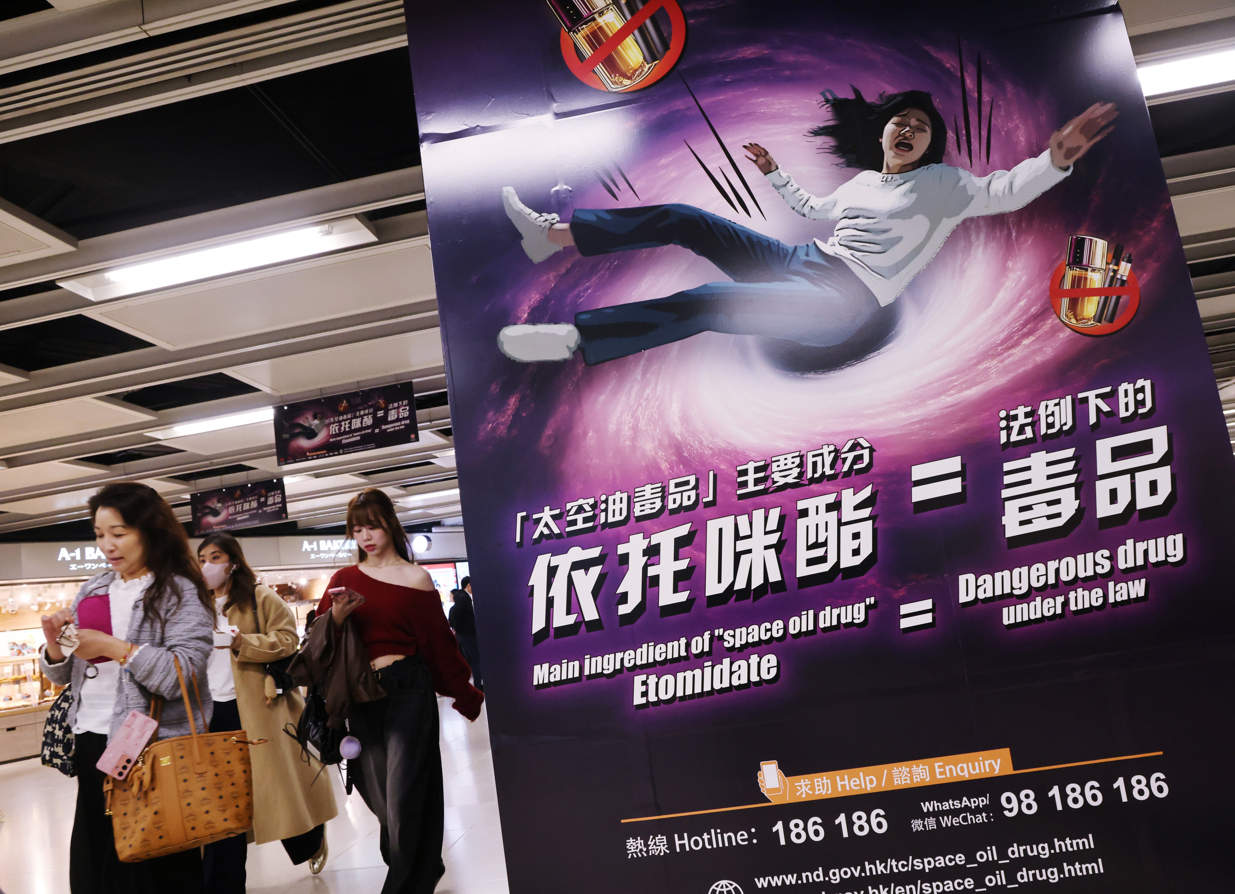 People pass by a poster warning about the dangers of etomidate, or “space oil”, at an MTR station in Hong Kong in February. Photo: Jelly Tse
