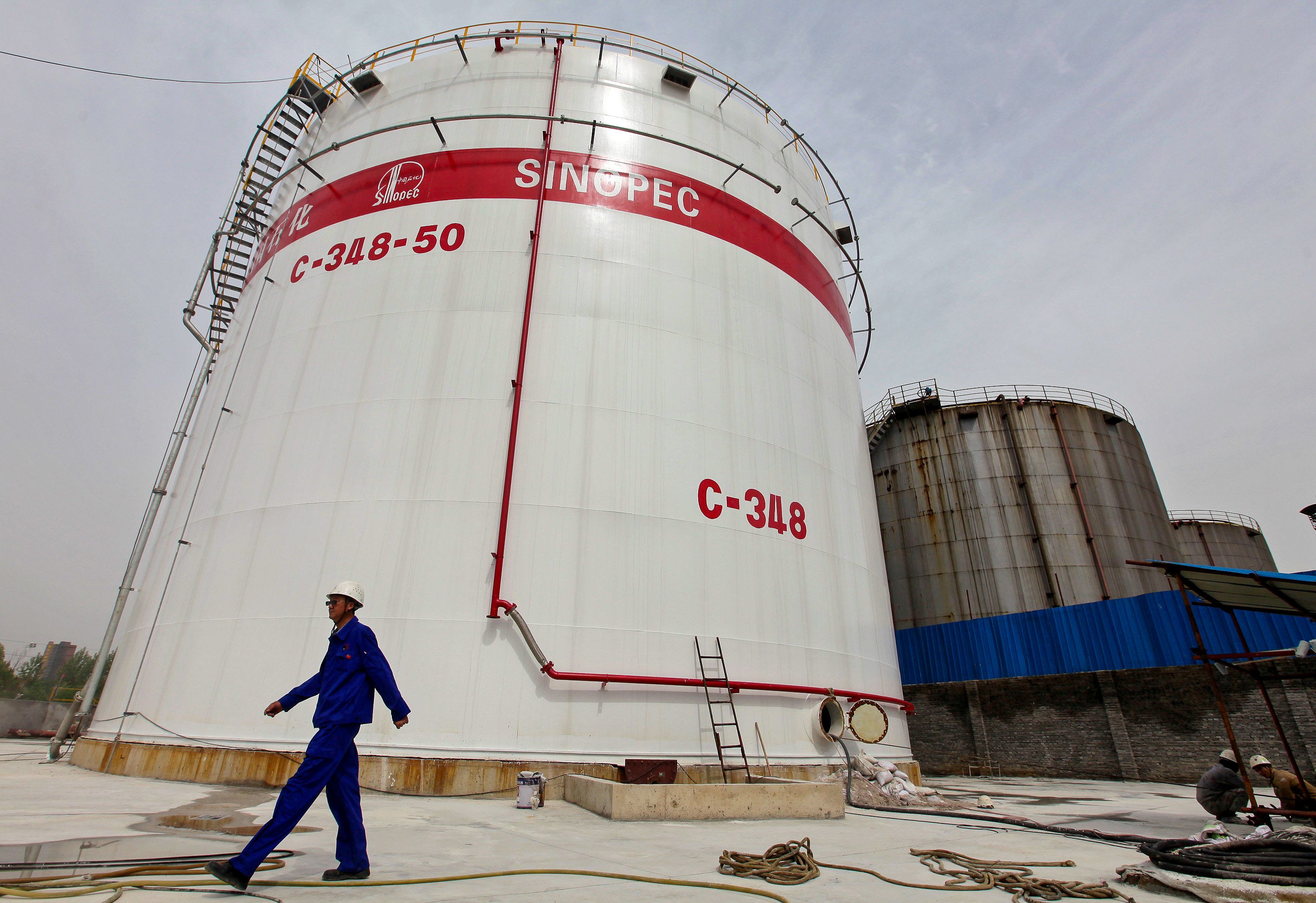 An employee passes tanks at a Sinopec refinery in Wuhan, Hubei province. Photo: Reuters