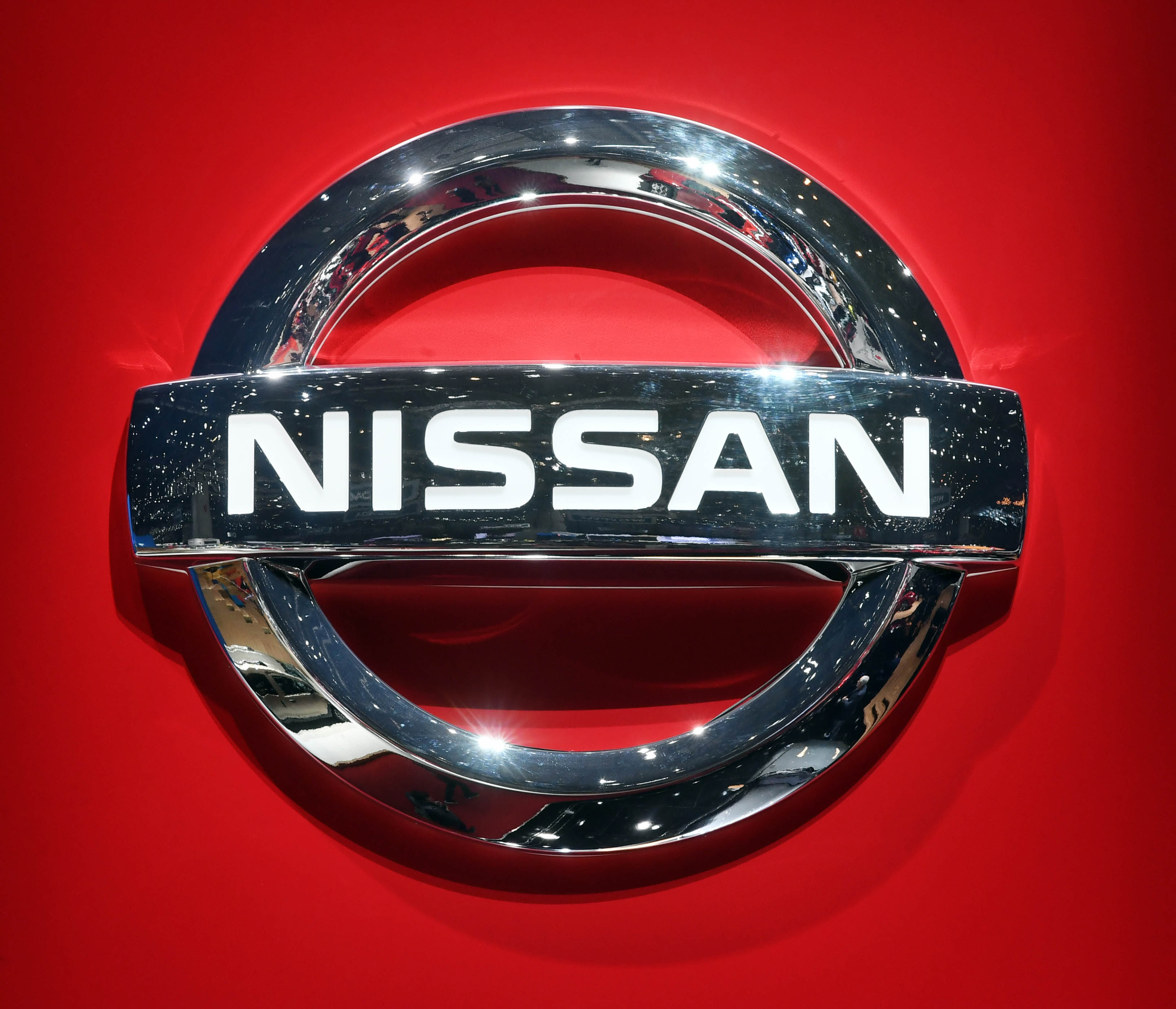 A Nissan logo is seen on a car at a Swiss auto expo. The Japanese carmaker has indicated broad plans to cut output. Photo: dpa