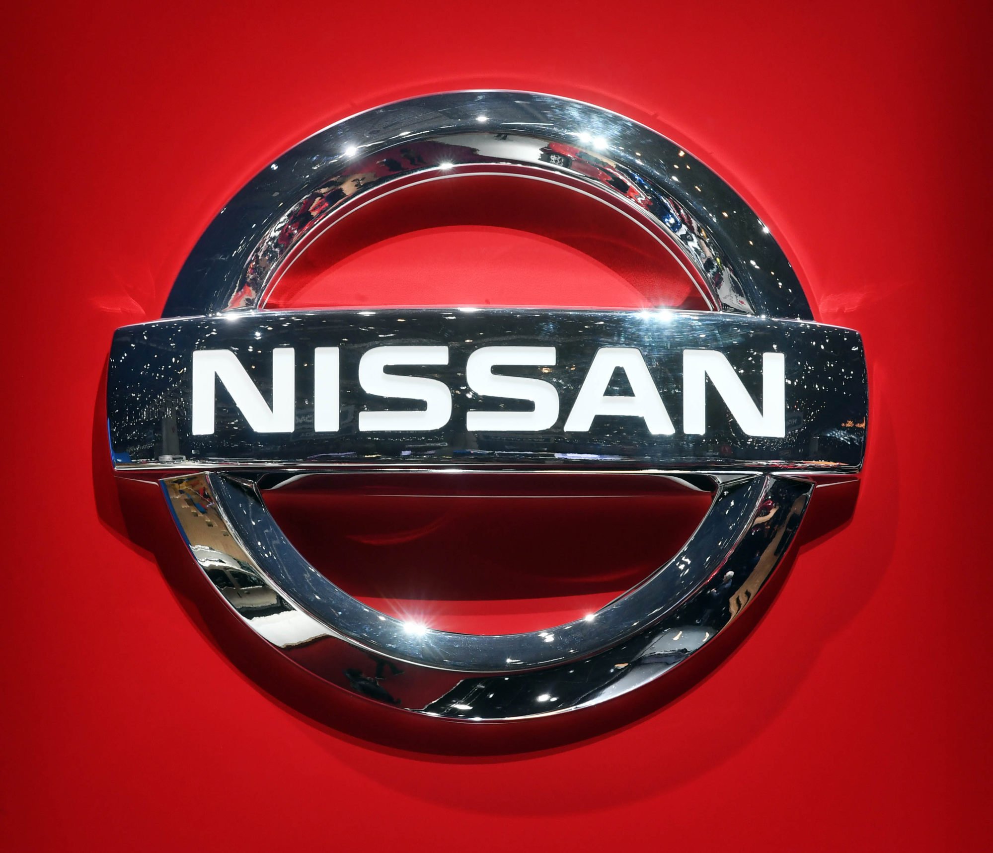 A Nissan logo is seen on a car at a Swiss auto expo. Nissan has indicated broad plans to cut output. Photo: dpa A Nissan logo is seen on a car at a Swiss auto expo. Nissan has indicated broad plans to cut output. Photo: dpa