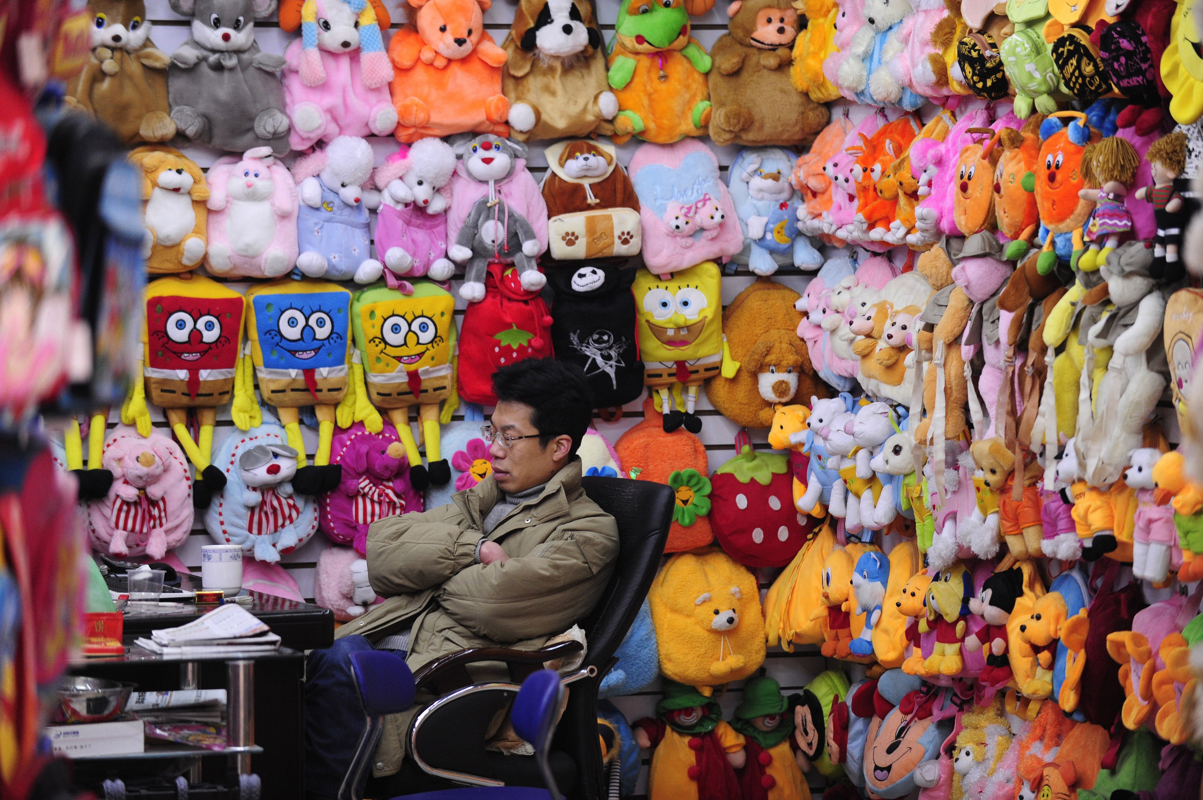 A trader takes a nap at a stall selling toys inside the world’s largest wholesale market for small commodities in Yiwu, Zhejiang province. Small traders in China have been hit hard by US tariffs since April. Photo: AFP