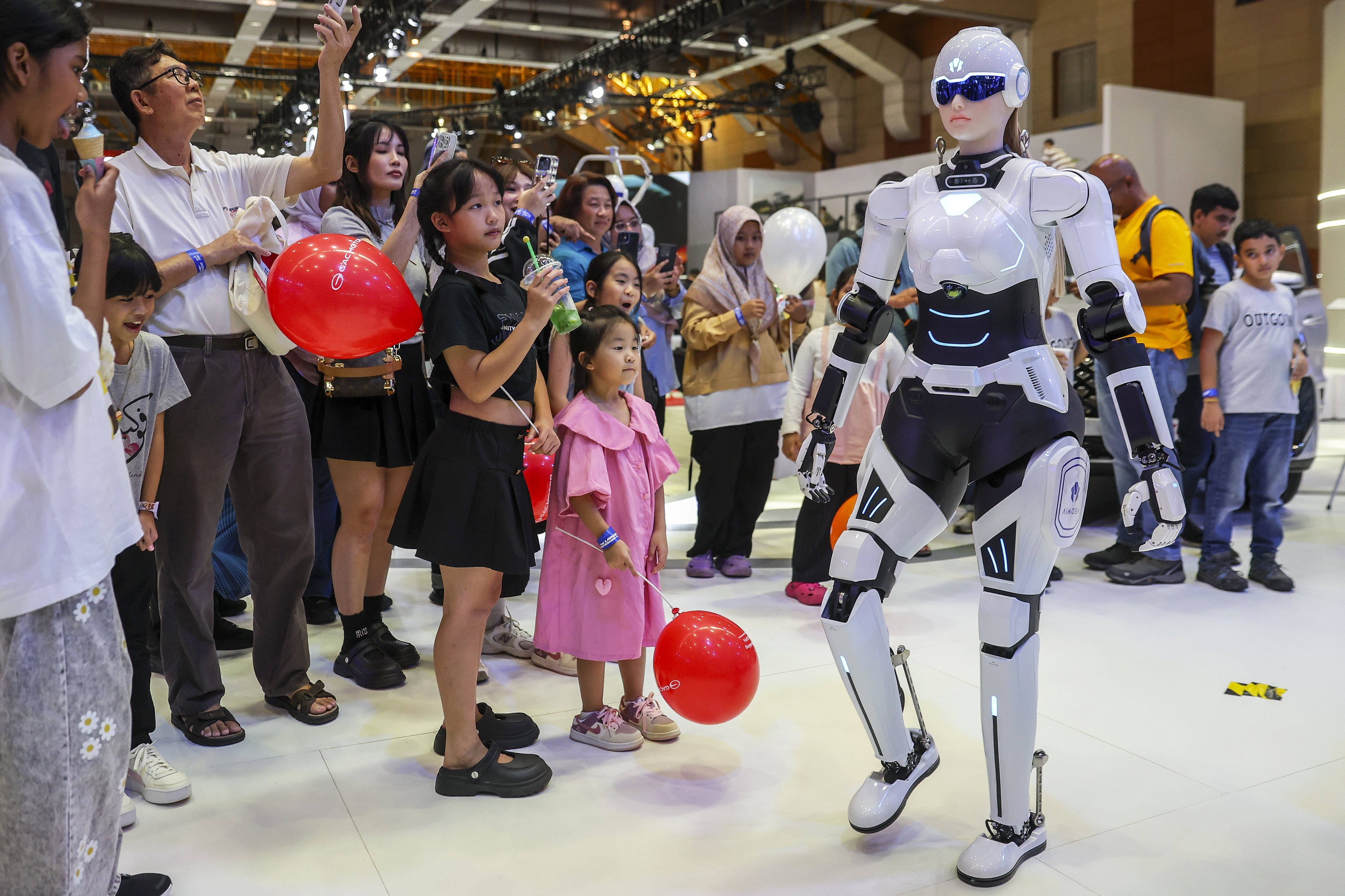 An AI robot sales assistant walks as visitors look on during the Malaysia Autoshow 2025 in Kuala Lumpur on May 10. Photo: EPA-EFE