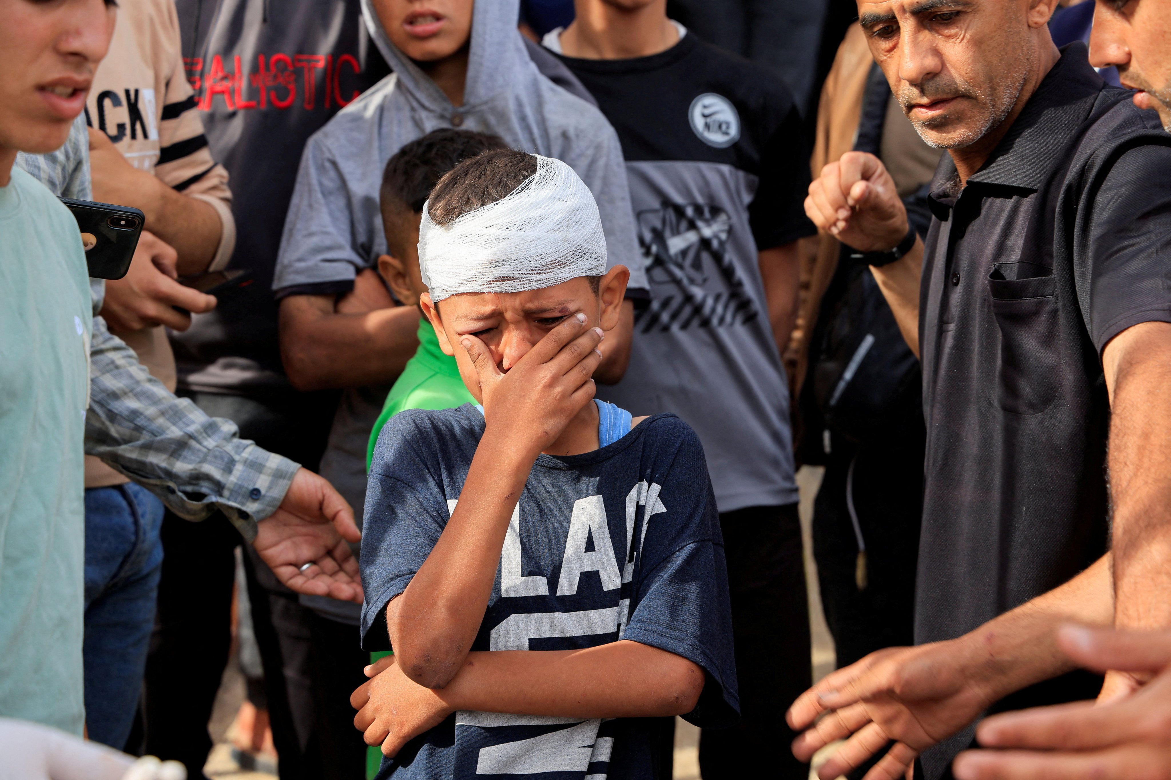 An injured Palestinian child weeps over his brothers, who were killed in Israeli strikes, at Nasser hospital in Khan Younis. Photo: Reuters