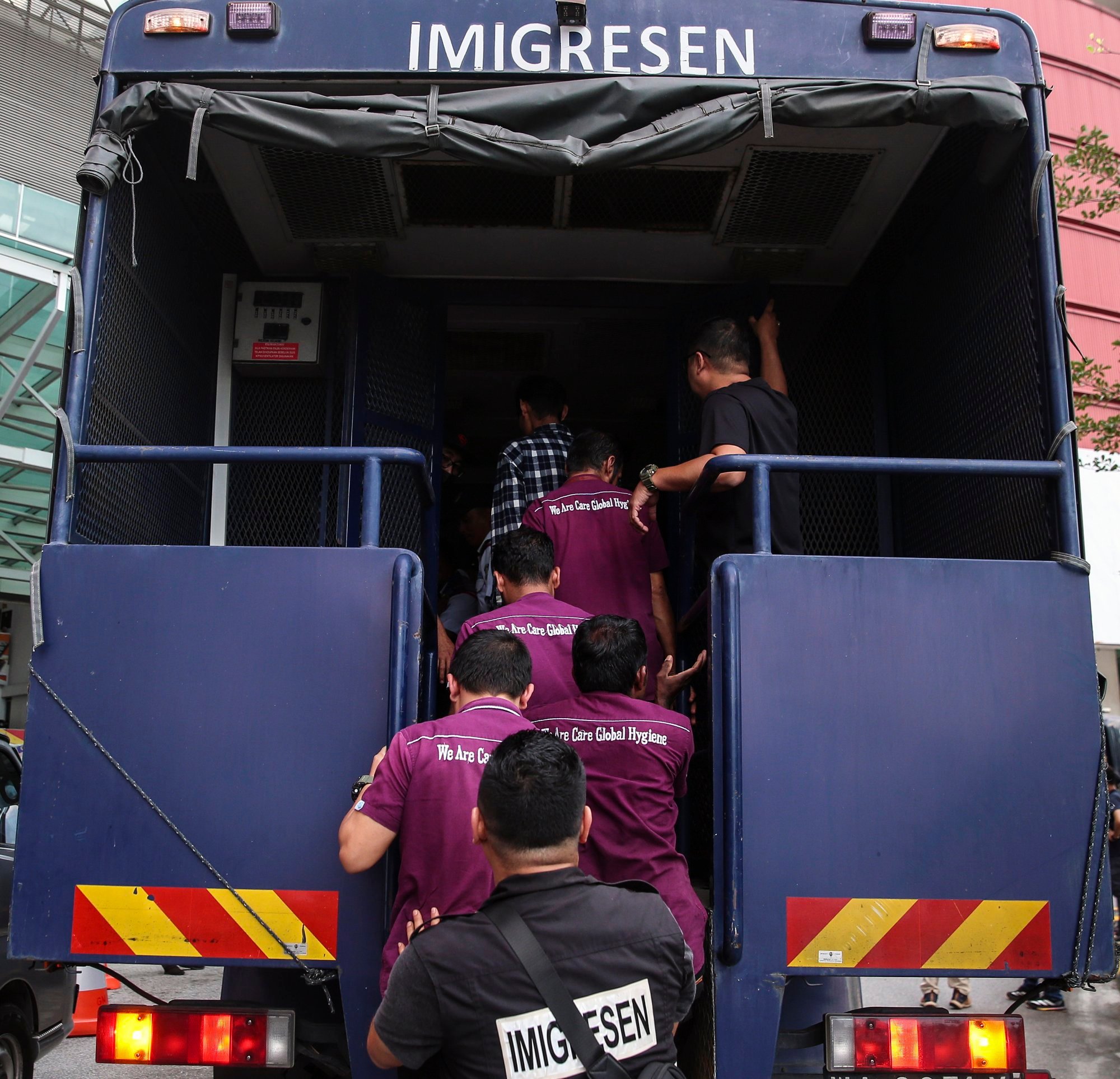 Illegal immigrants board an immigration vehicle during a Malaysia Immigration raid in August last year. Photo: EPA-EFE