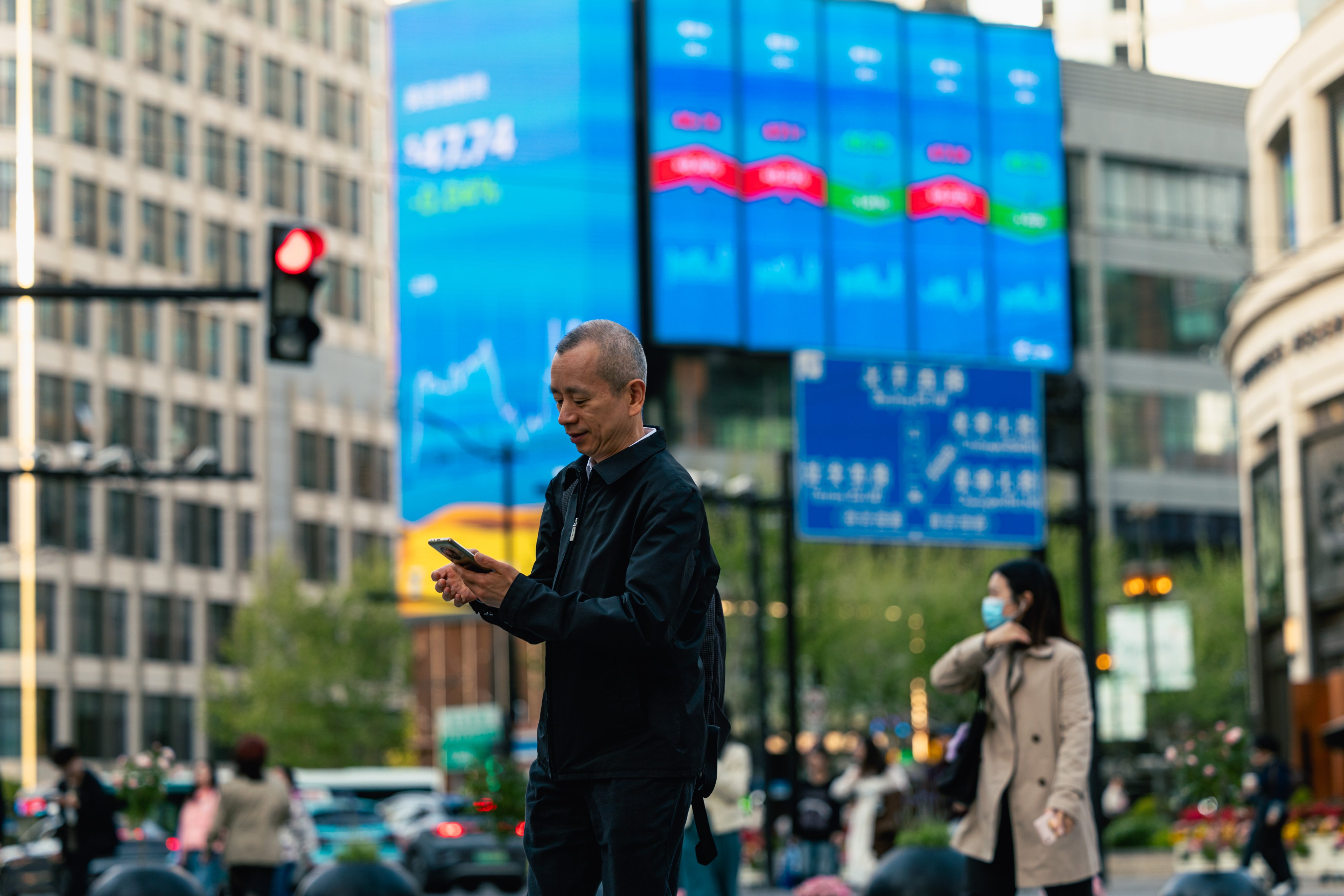 Screens show stock exchange and economic data in Shanghai on April 14. Photo: EPA-EFE