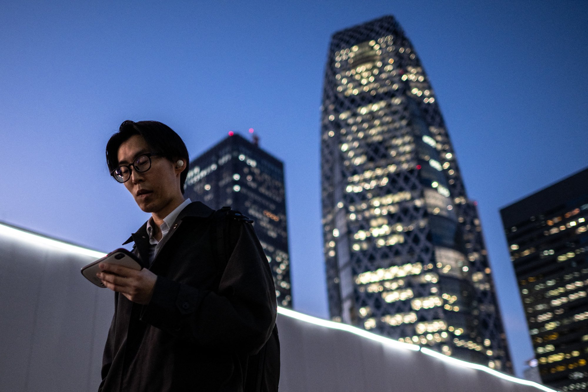 A man looks at his phone while walking in Tokyo’s Shinjuku district last year. One in three respondents reported stiff shoulders or neck pain due to prolonged phone use. Photo: AFP A man looks at his phone while walking in Tokyo’s Shinjuku district last year. One in three respondents reported stiff shoulders or neck pain due to prolonged phone use. Photo: AFP