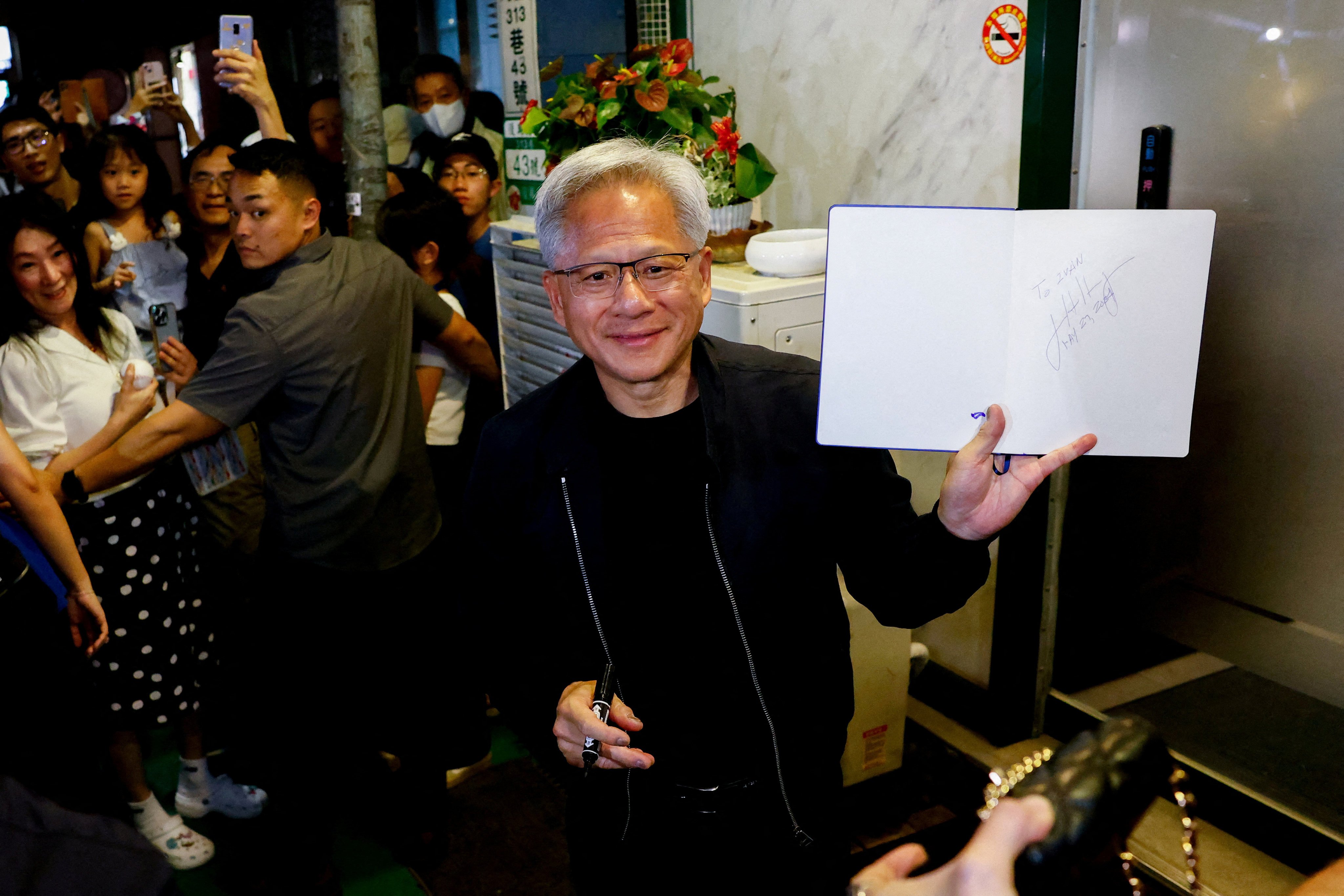 Nvidia CEO Jensen Huang interacts with the media and supporters outside a restaurant in Taipei on May 16. Photo: Reuters