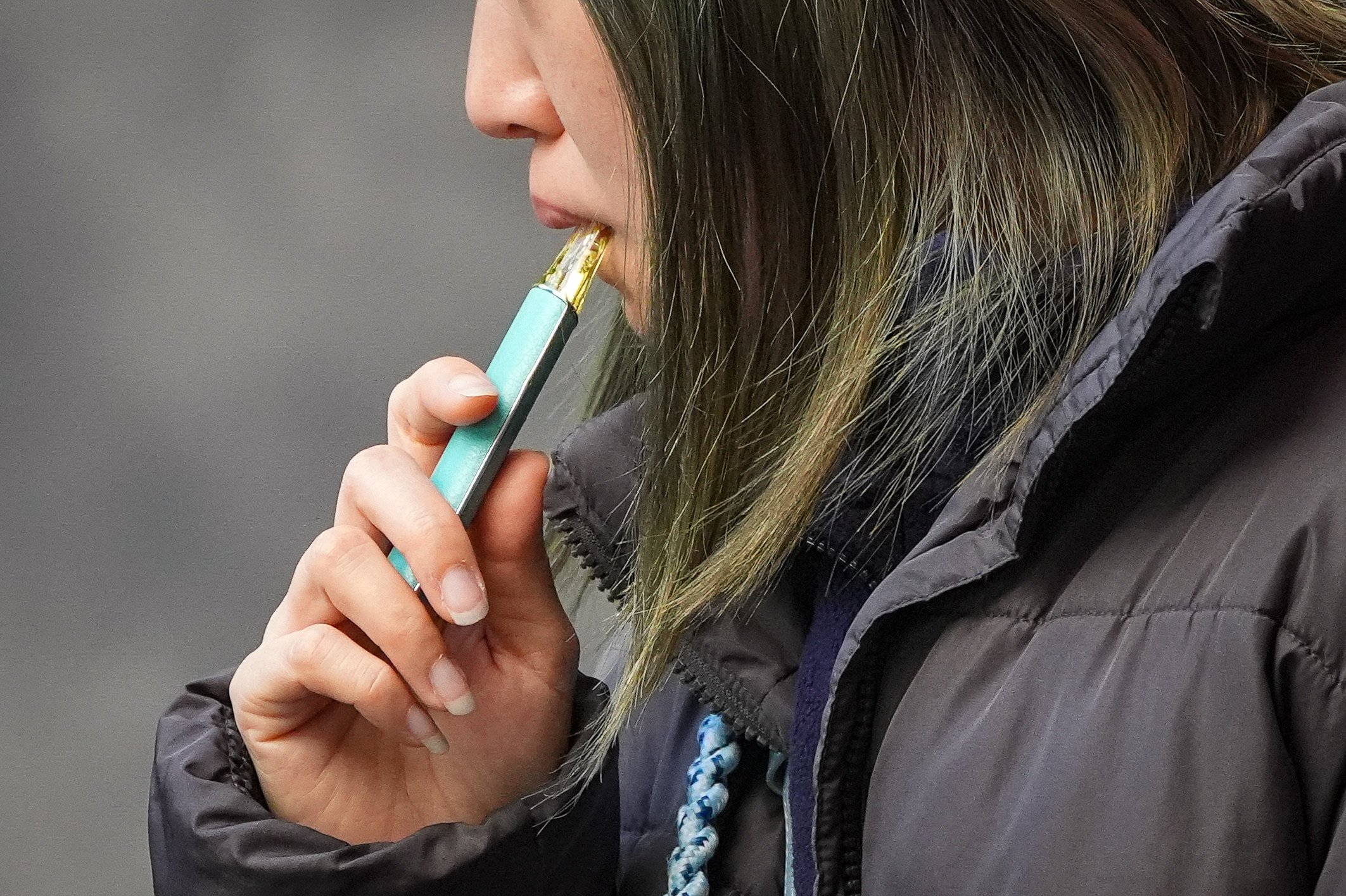 A woman smokes e-cigarette in Mong Kok. Photo: Eugene Lee