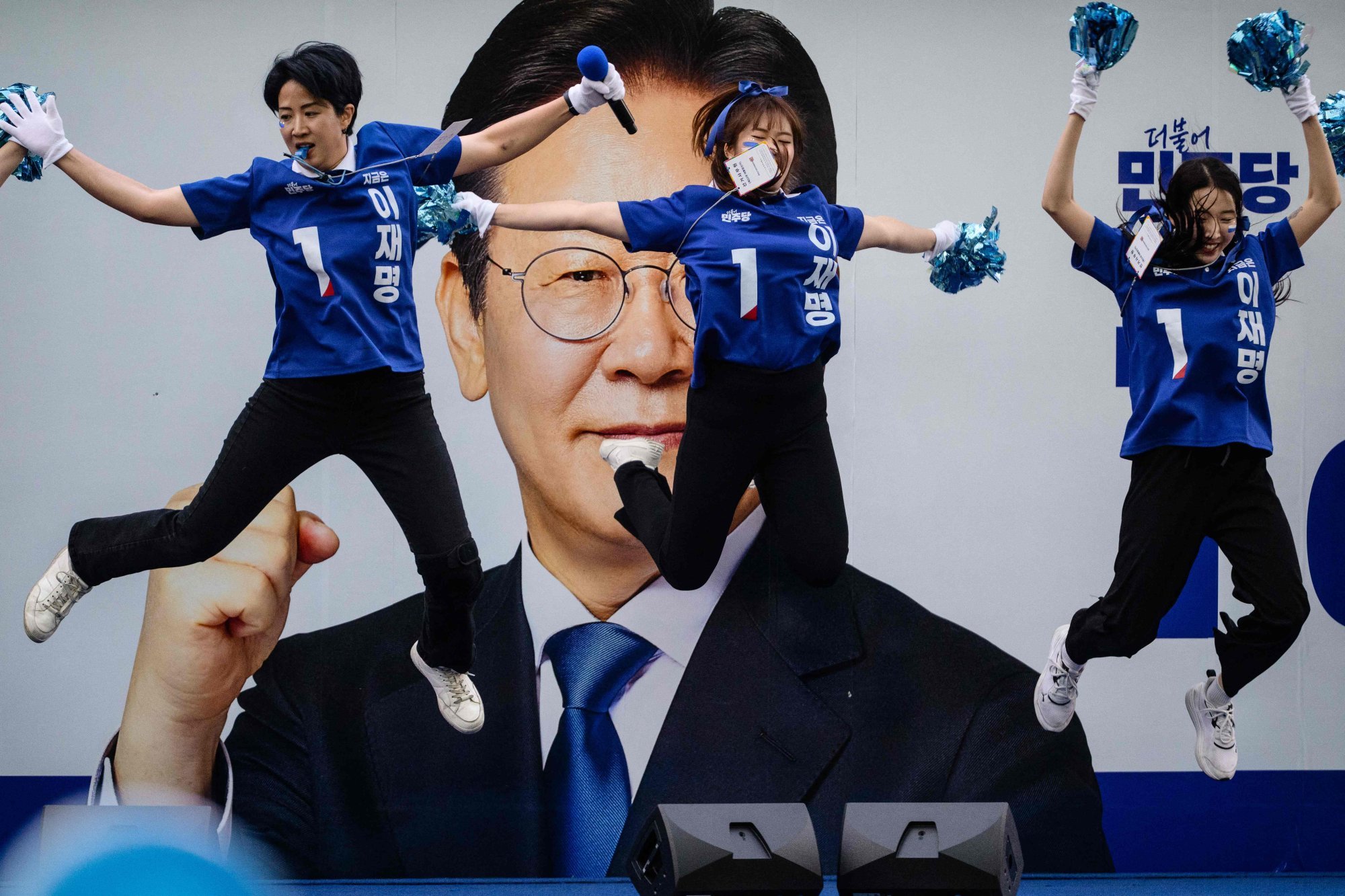 Supporters of South Korean Lee Jae-myung (pictured on poster) of the Democratic Party dance before the televised presidential debate, outside the SBS studio in Seoul on Sunday. Photo: AFP Supporters of South Korean Lee Jae-myung (pictured on poster) of the Democratic Party dance before the televised presidential debate, outside the SBS studio in Seoul on Sunday. Photo: AFP