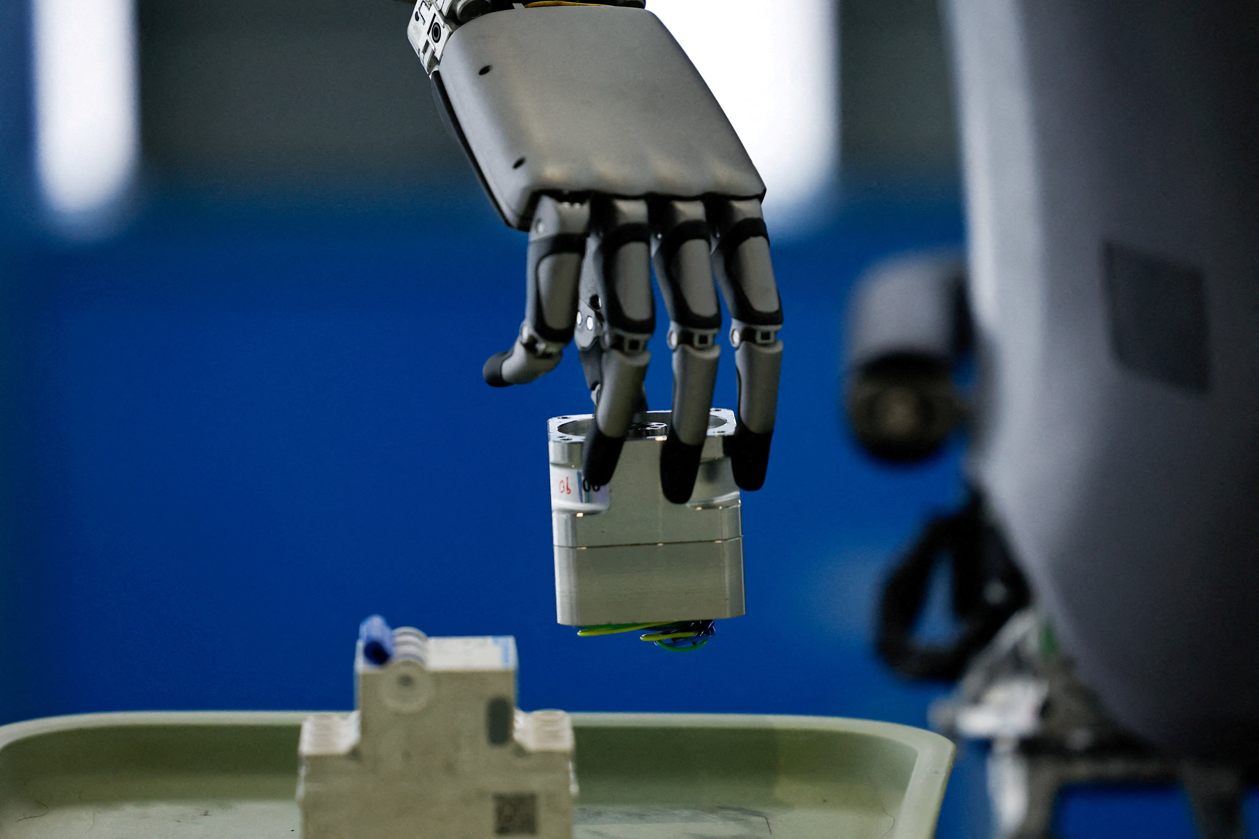 A UBTech humanoid robot picks up an object during a demonstration simulating a factory’s assembly line. Photo: Reuters