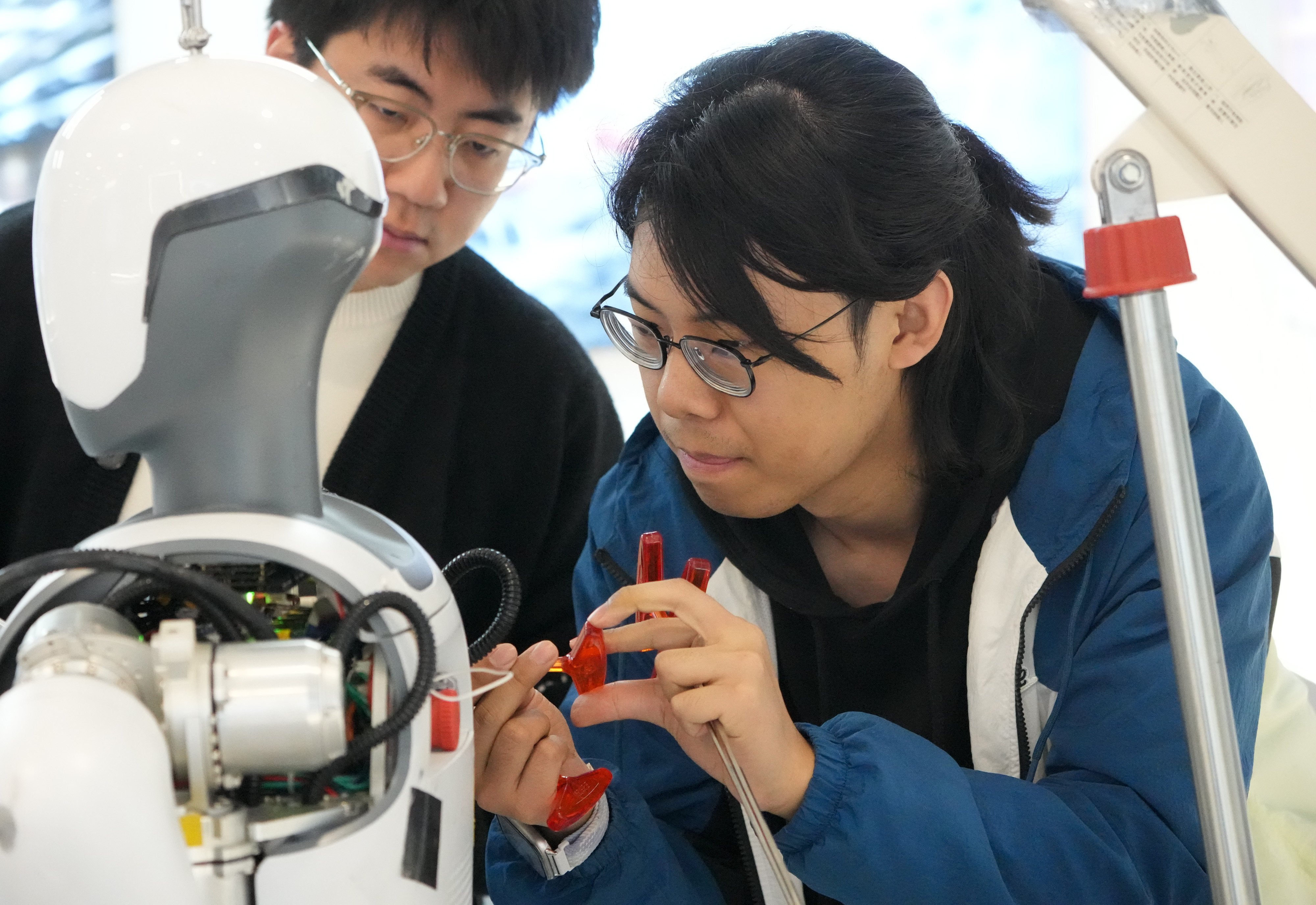 Workers at Hangzhou-based Deep Robotics debug a humanoid robot on February 28. Photo: Xinhua