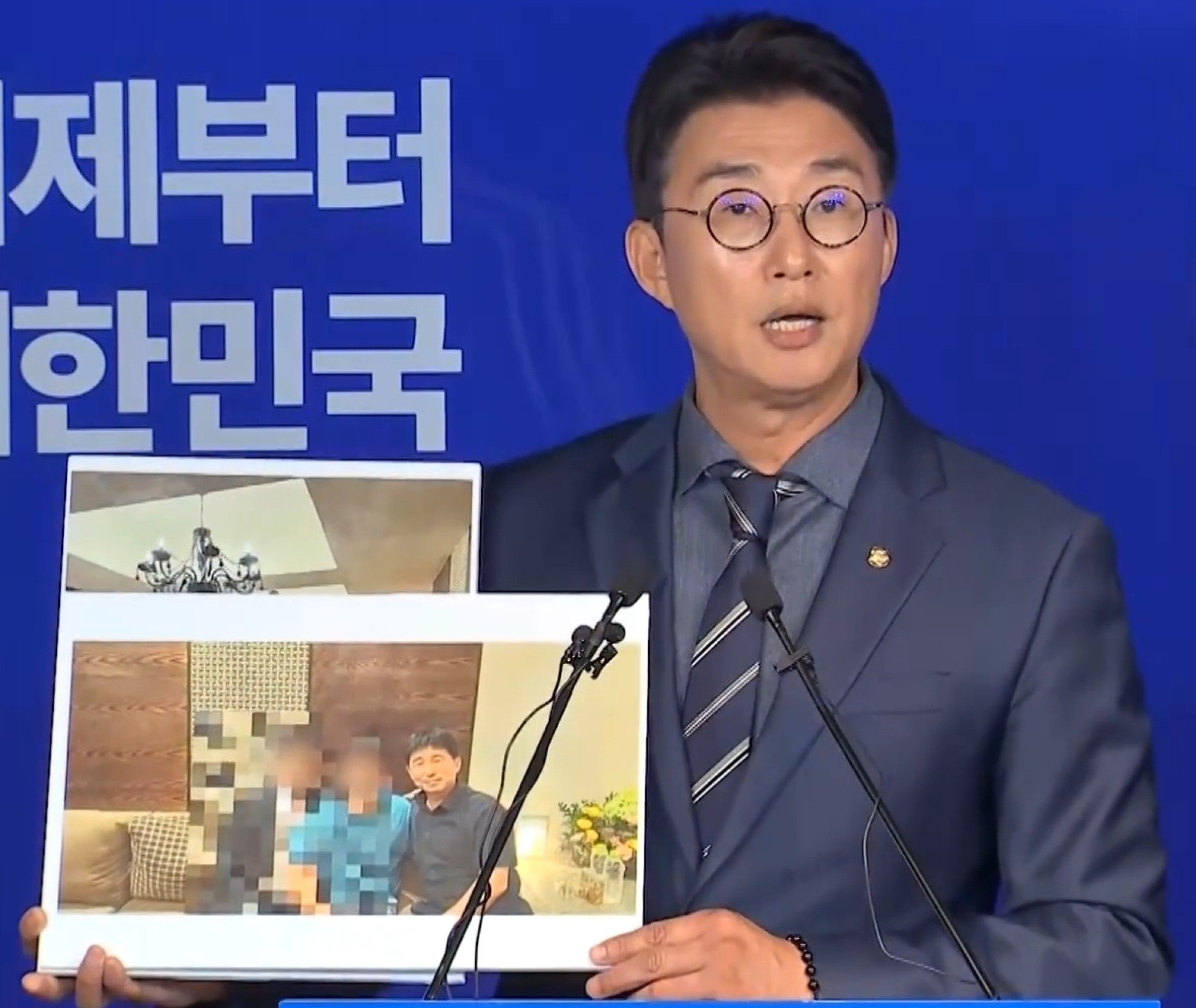 DPK spokesman Noh Jong-myeon shows a photo of Jee Kui-youn in a partitioned private room at a “room salon”. Photo: MBC DPK spokesman Noh Jong-myeon shows a photo of Jee Kui-youn in a partitioned private room at a “room salon”. Photo: MBC