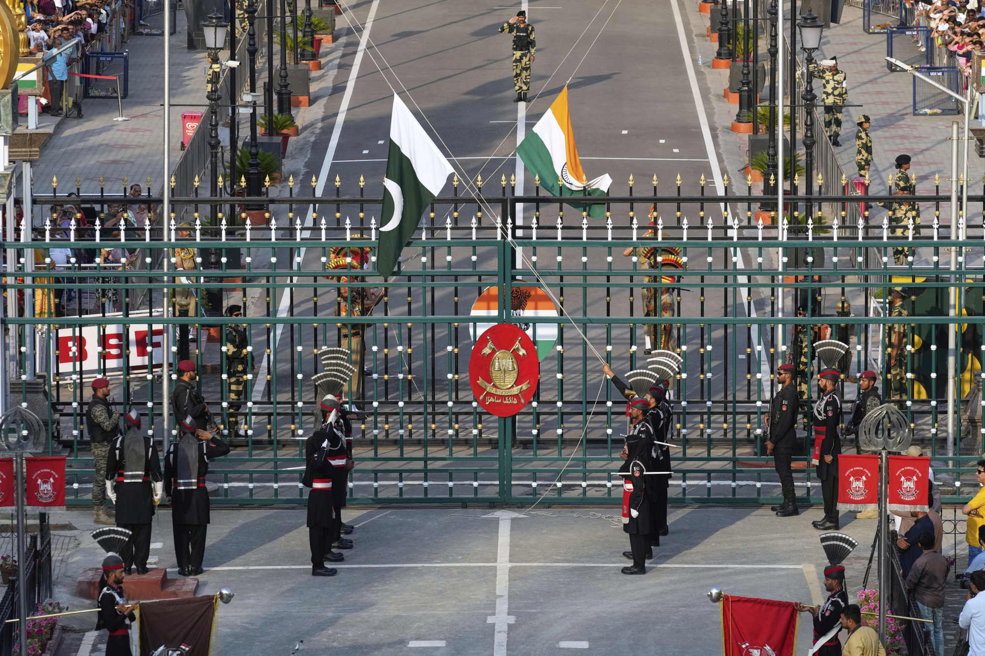 Pakistan’s Rangers in black, and Indian Border Security Forces soldiers, behind the gate, lower their flags during a daily closing ceremony at a joint post on the Pakistan and India border. Photo: AP Pakistan’s Rangers in black, and Indian Border Security Forces soldiers, behind the gate, lower their flags during a daily closing ceremony at a joint post on the Pakistan and India border. Photo: AP