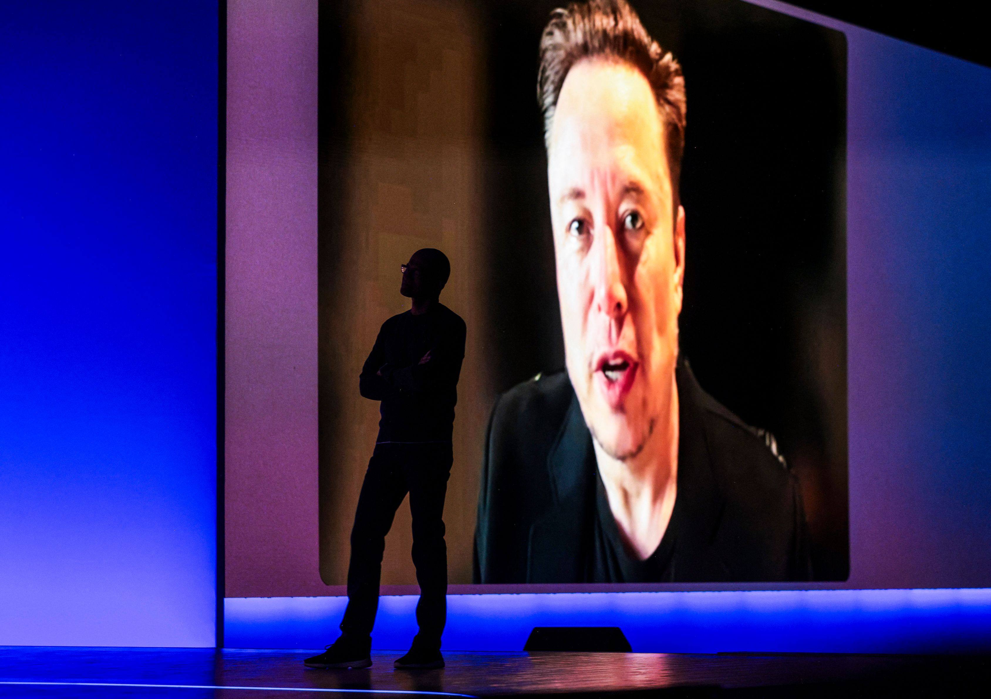 Microsoft CEO Satya Nadella is silhouetted as a pre-recorded interview with Elon Musk is played. Photo: AFP