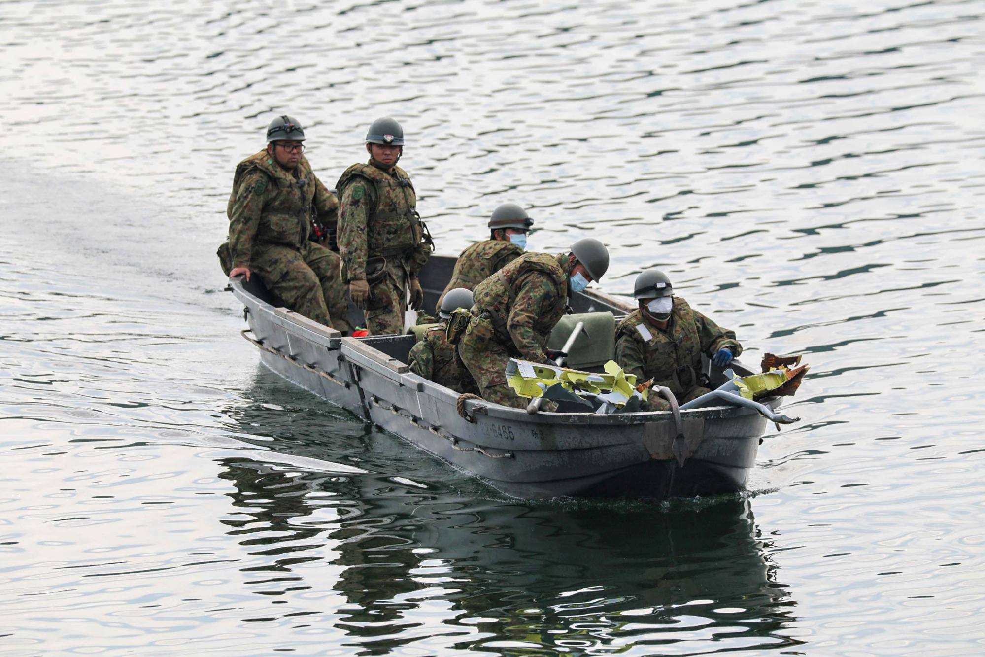 Japanese servicemen transport debris, believed to be part of the T-4 aircraft that crashed, at Lake Iruka reservoir in Inuyama City, Aichi prefecture, on May 15. Photo: Jiji Press / AFP
