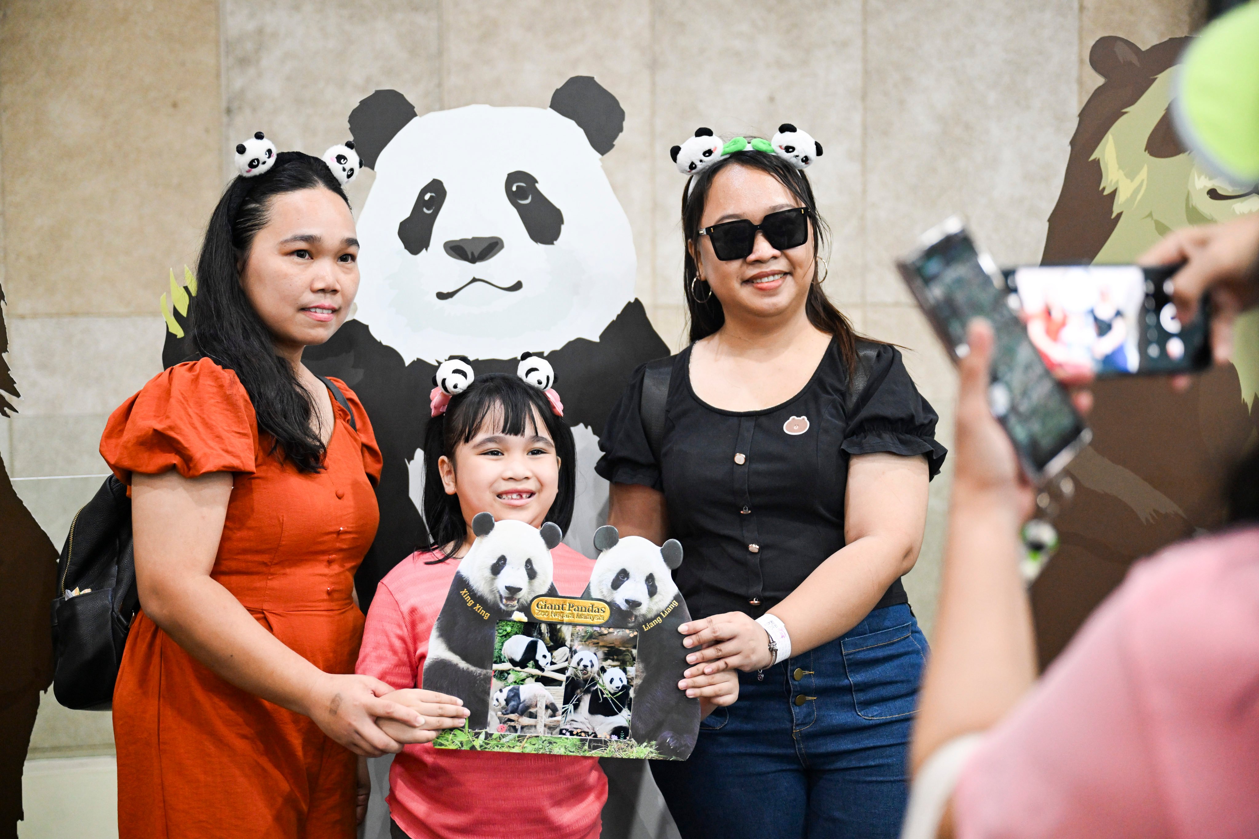 People pose for photos at the panda habitat in Kuala Lumpur’s National Zoo on Saturday. Photo: Xinhua