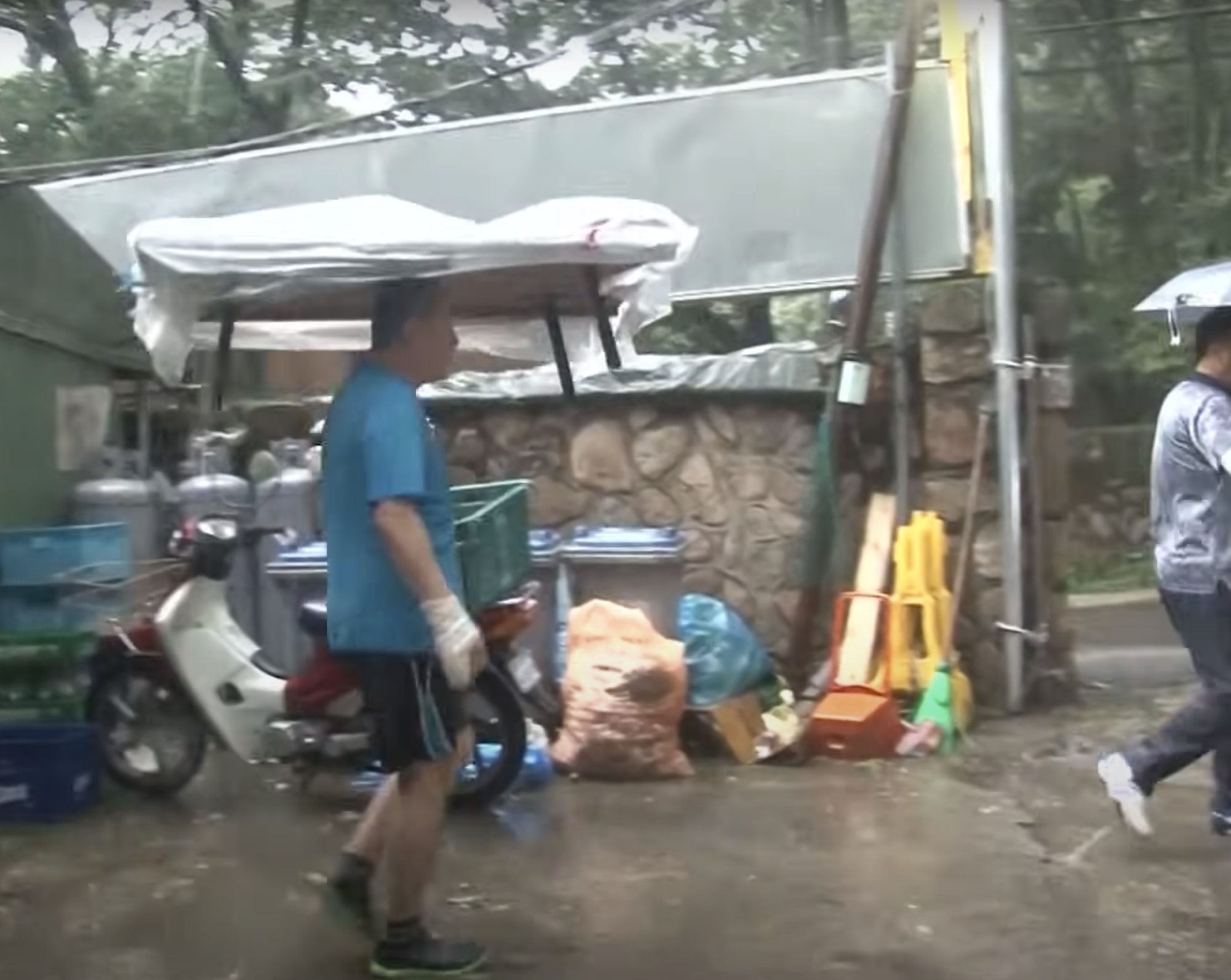On rainy days, the eatery boss simply covers the loaded table with a plastic sheet and turns it into a de facto umbrella. Photo: YouTube