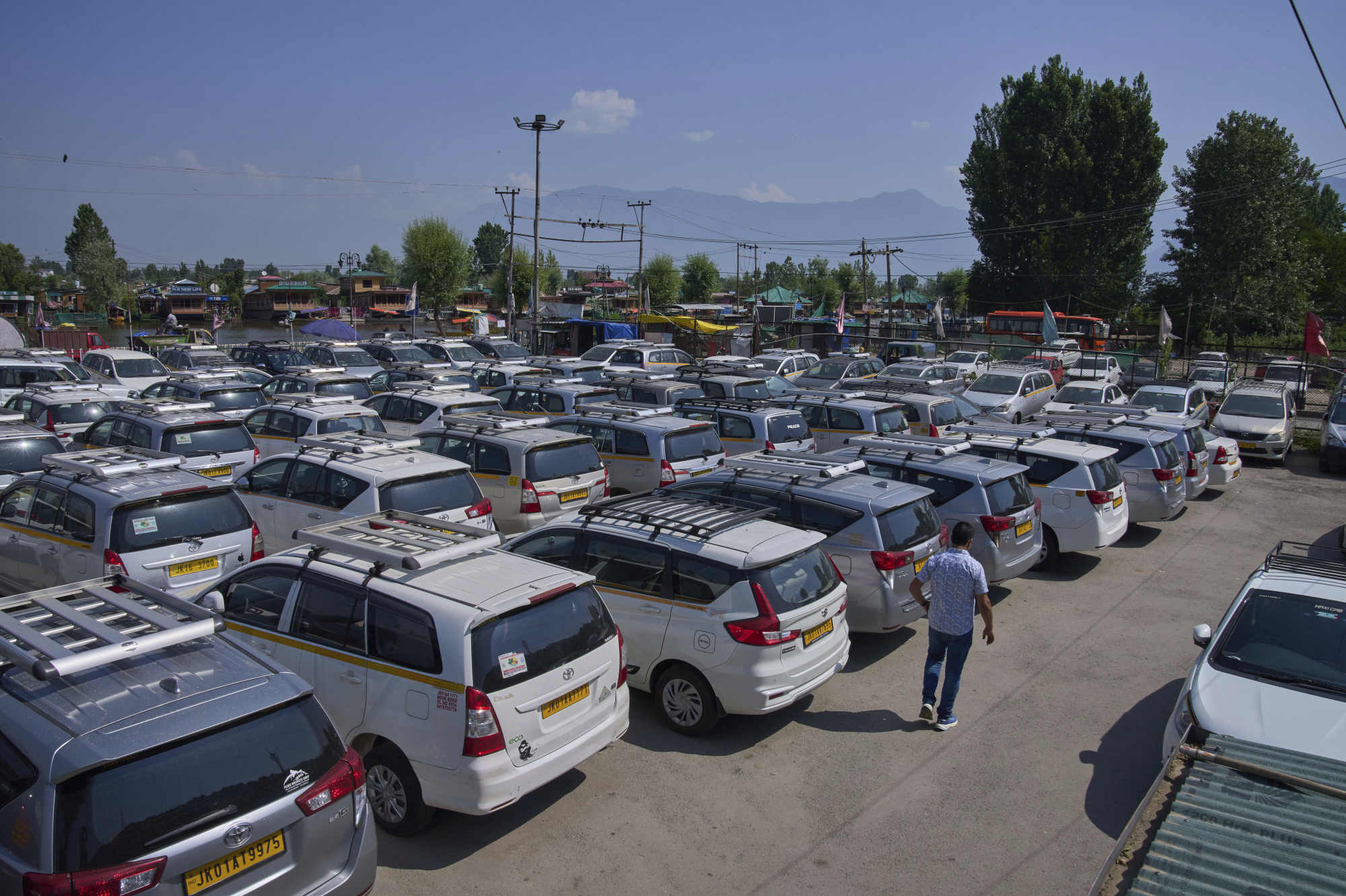 A Kashmiri taxi driver walks past hundreds of tourist cabs parked idle in Srinagar. Photo: AP A Kashmiri taxi driver walks past hundreds of tourist cabs parked idle in Srinagar. Photo: AP