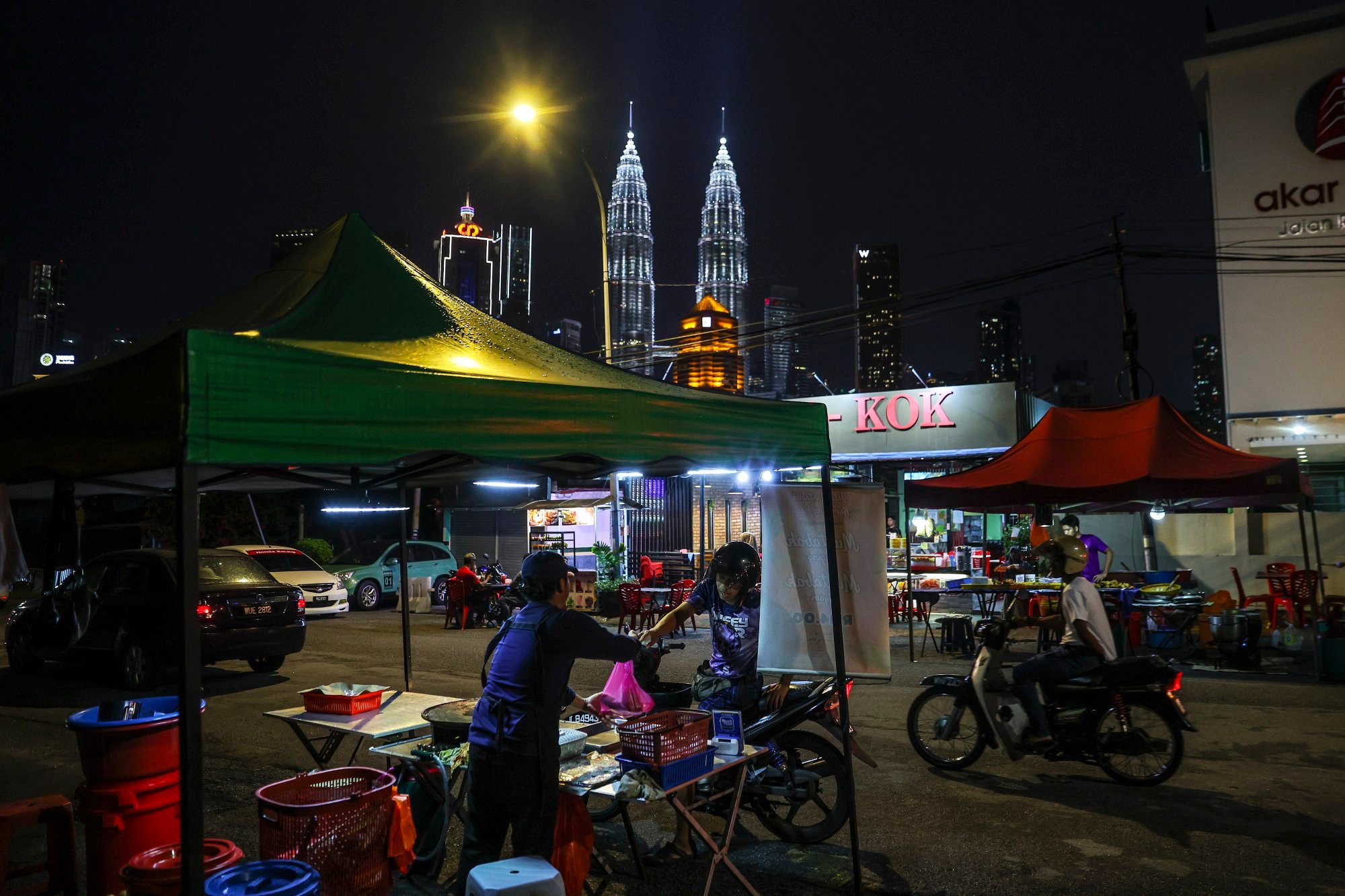 A seller hands over food to his customer with the Petronas Twin Towers in the background in Kuala Lumpur, Malaysia, on May 13. Malaysia can look to implement measures to offset the potential turmoil of Trump’s tariffs. Photo: EPA-EFE A seller hands over food to his customer with the Petronas Twin Towers in the background in Kuala Lumpur, Malaysia, on May 13. Malaysia can look to implement measures to offset the potential turmoil of Trump’s tariffs. Photo: EPA-EFE