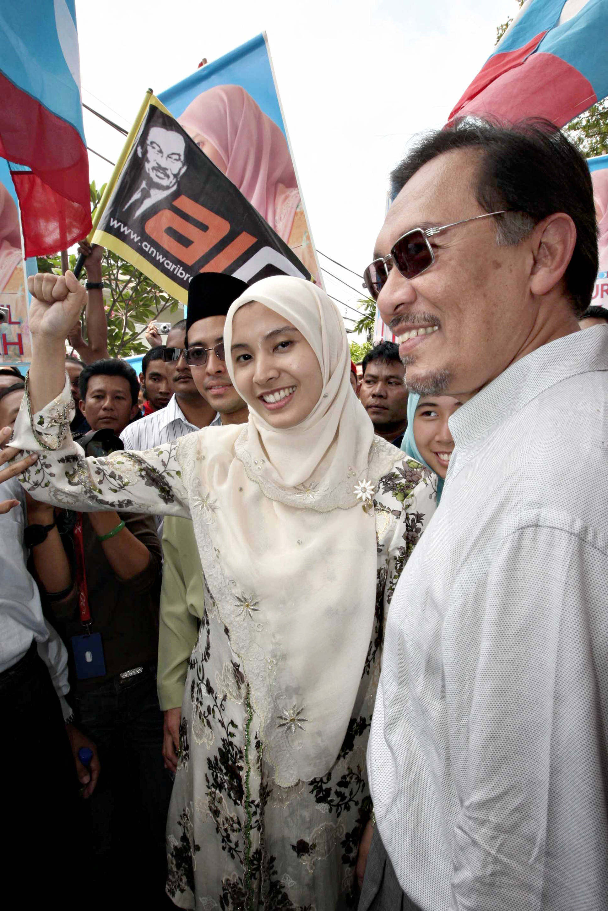 Nurul Izzah Anwar (centre) raises her first while accompanied by her father Anwar outside an election nomination station in 2008. Photo: AFP Nurul Izzah Anwar (centre) raises her first while accompanied by her father Anwar outside an election nomination station in 2008. Photo: AFP