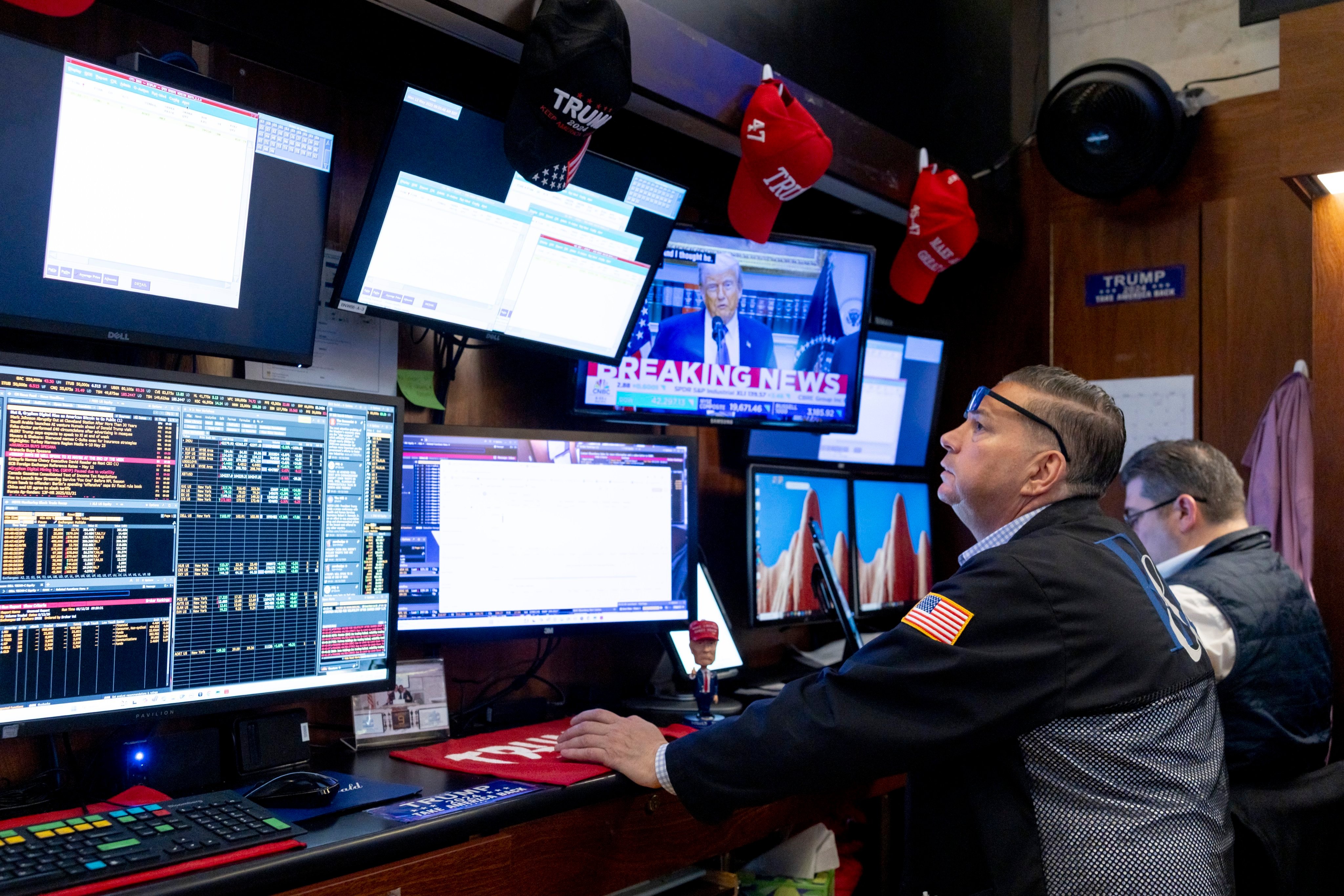 US President Donald Trump is seen on a television screen while a trader works on the floor of the New York Stock Exchange in New York on May 12. Photo: EPA-EFE