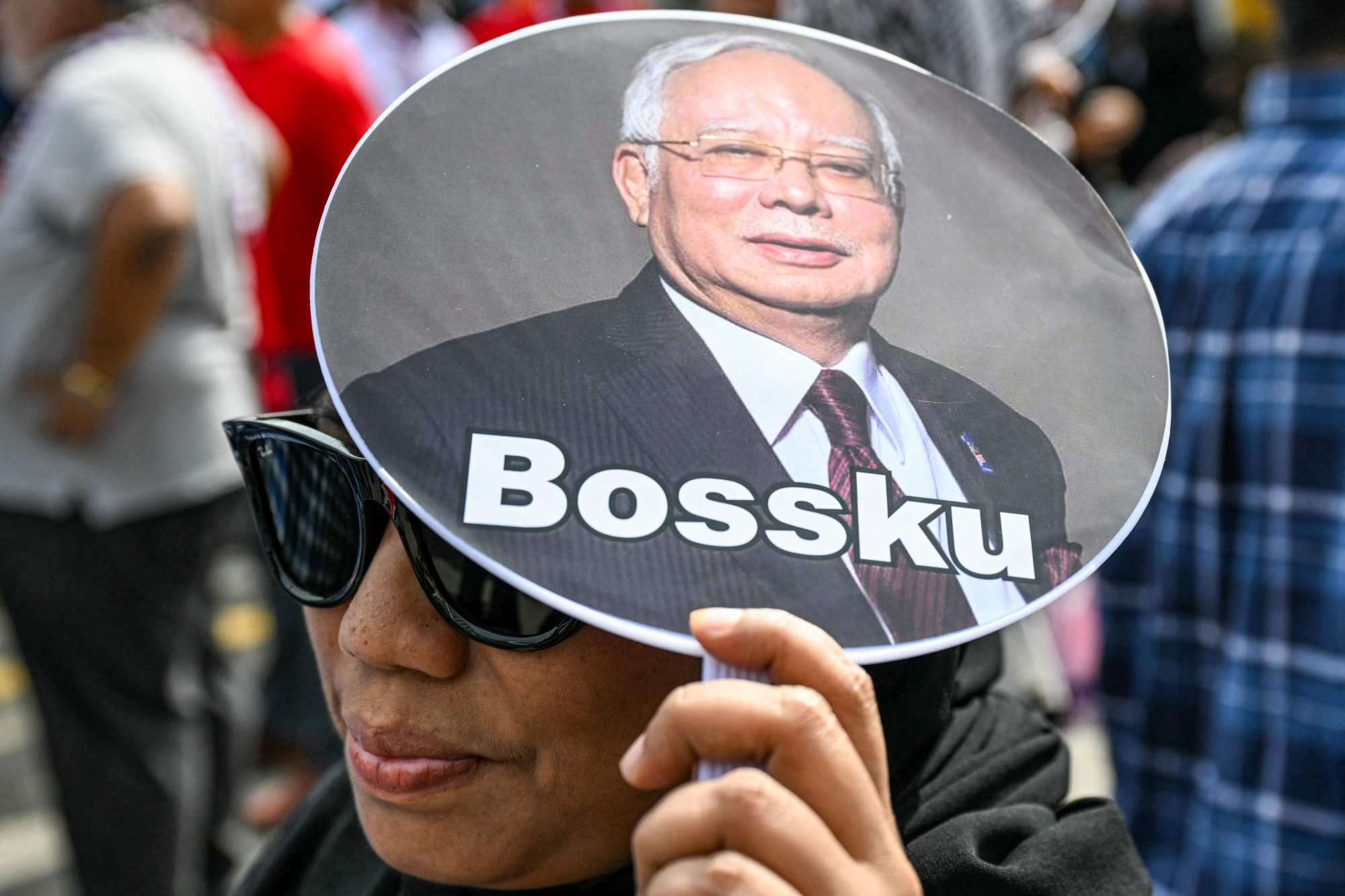 A woman holds a hand fan bearing a photo of jailed former Malaysian prime minister Najib Razak that reads “My boss” in January. Photo: AFP A woman holds a hand fan bearing a photo of jailed former Malaysian prime minister Najib Razak that reads “My boss” in January. Photo: AFP