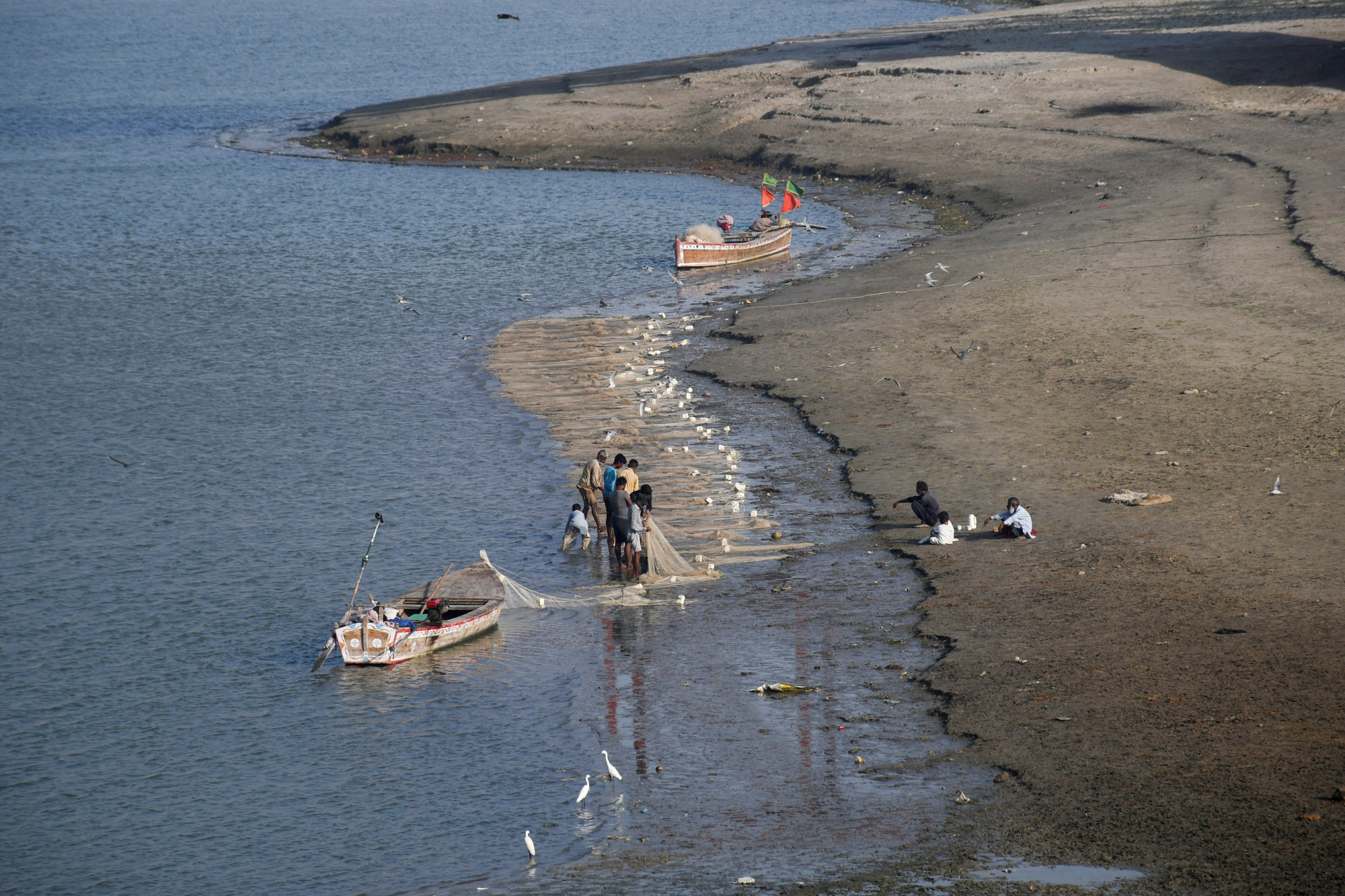 Fishermen clear a fishing net in the water on the partially dried up riverbed of the Indus River in Hyderabad, Pakistan. Photo: Reuters Fishermen clear a fishing net in the water on the partially dried up riverbed of the Indus River in Hyderabad, Pakistan. Photo: Reuters