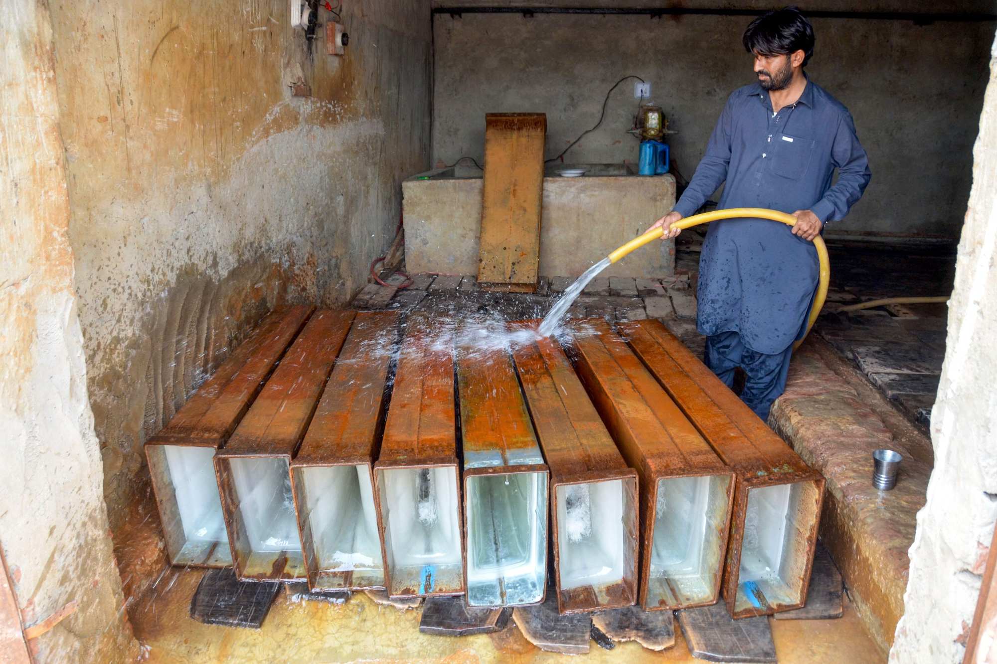 A worker sprays water to draw out ice blocks before loading them onto a vehicle at an ice factory on a hot summer day in Jaffarabad, Balochistan province, Pakistan on Saturday. Photo: AFP A worker sprays water to draw out ice blocks before loading them onto a vehicle at an ice factory on a hot summer day in Jaffarabad, Balochistan province, Pakistan on Saturday. Photo: AFP
