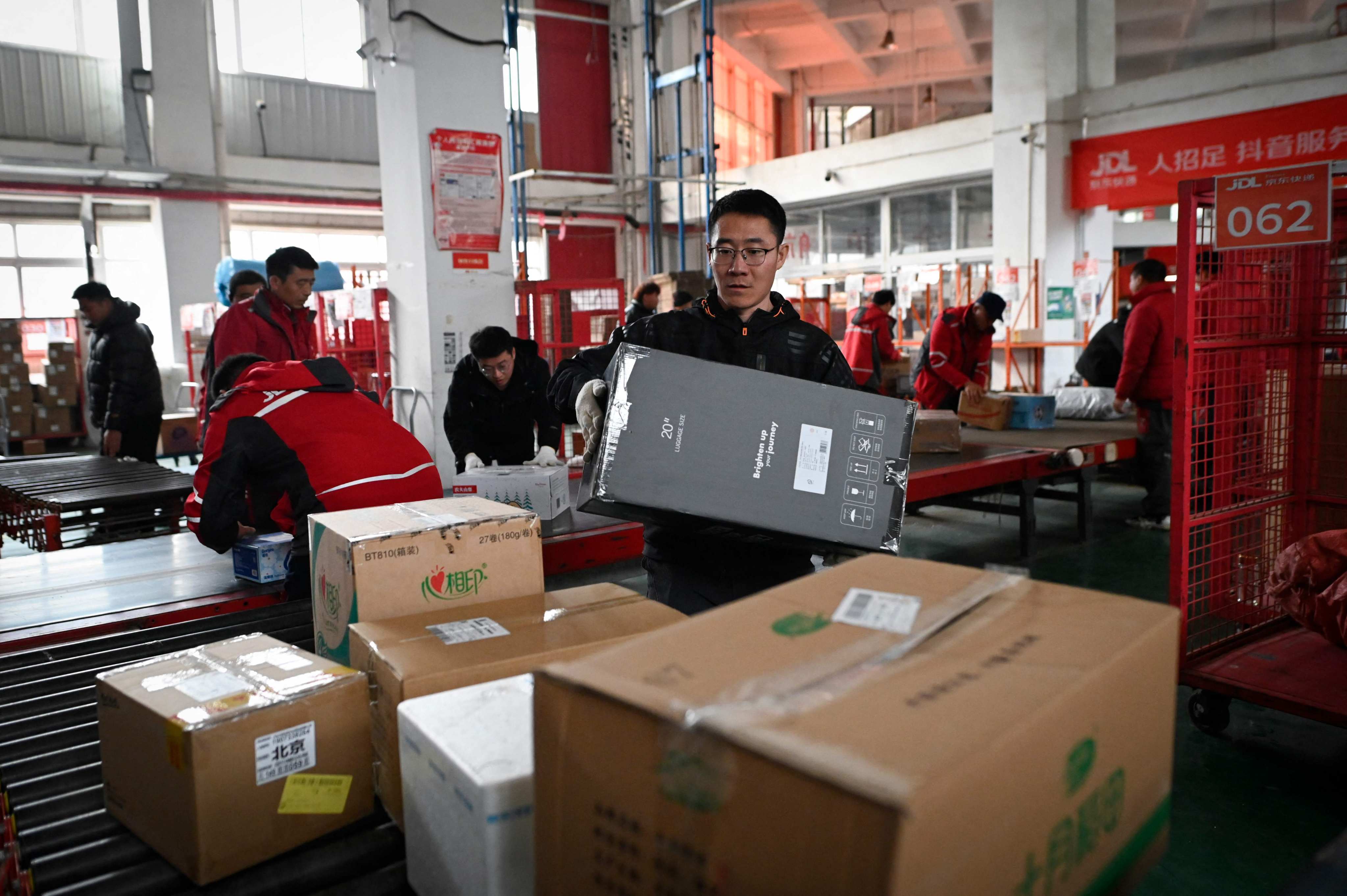 Workers sort packages for delivery at a JD.com warehouse in Beijing on November 11, 2024. Photo: AFP