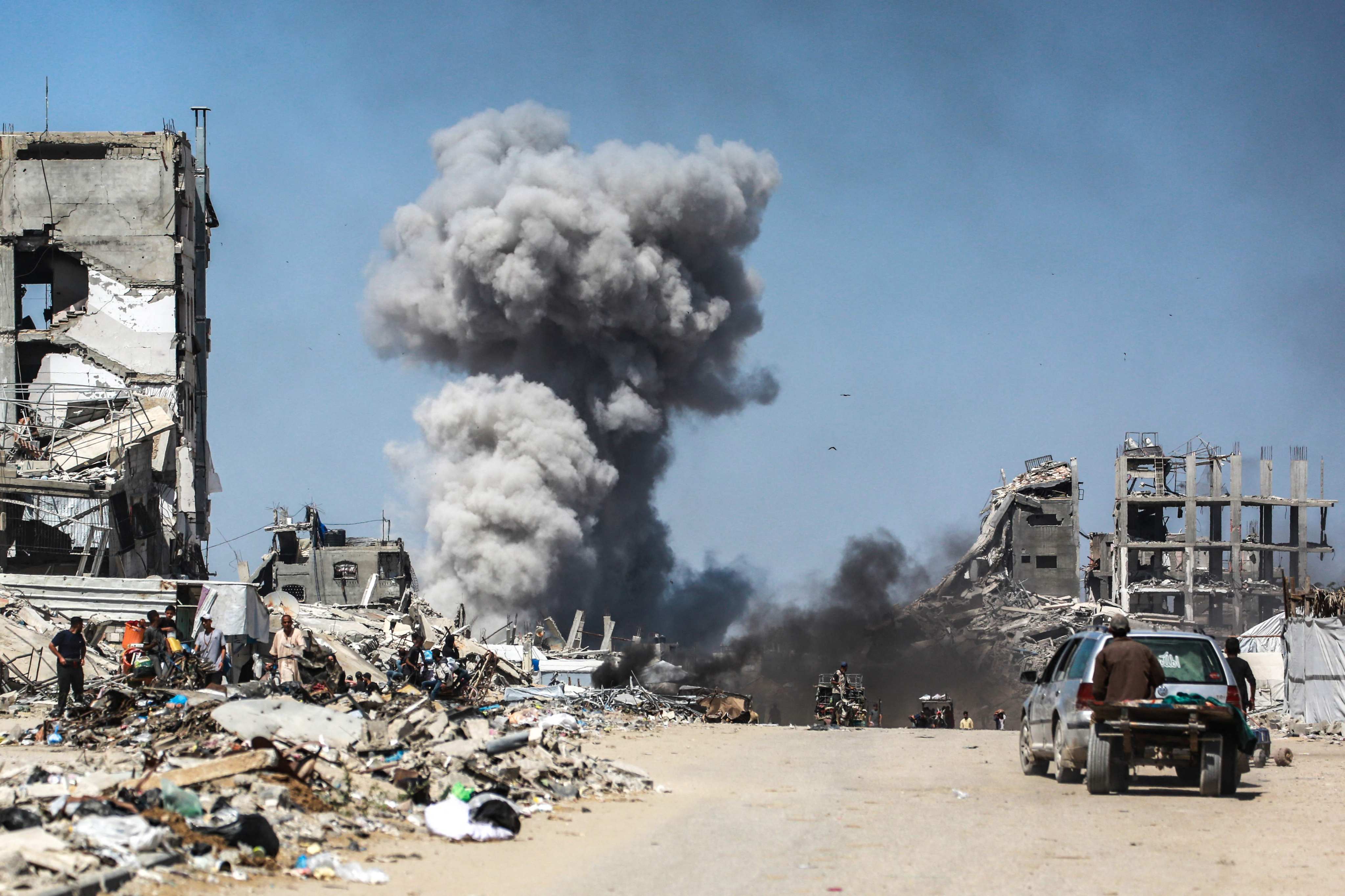 People watch as smoke billows following an Israeli strike in Jabalia, northern Gaza on Sunday. Photo: AFP