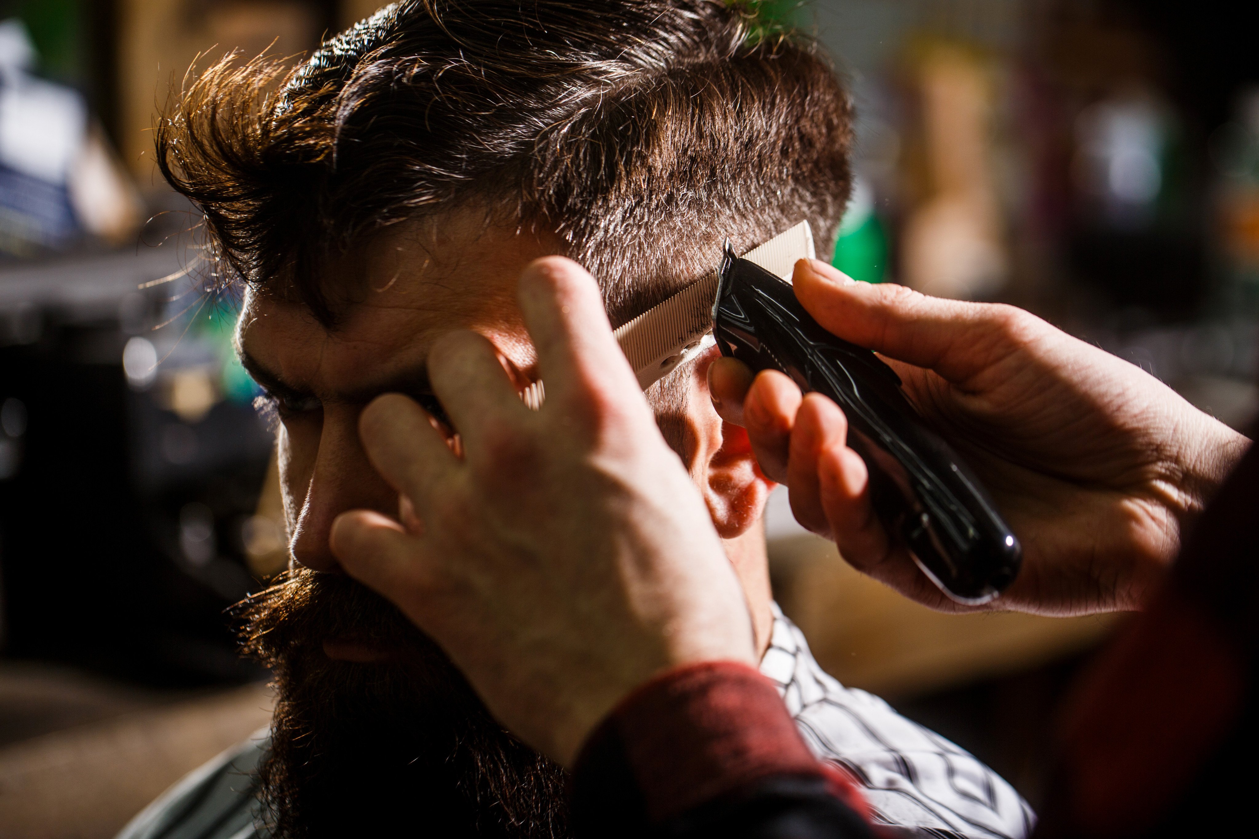 A barber giving a man a shave with hair clippers. A clerk in Kyoto was forced to shave his own head by an irate customer. Photo: Shutterstock