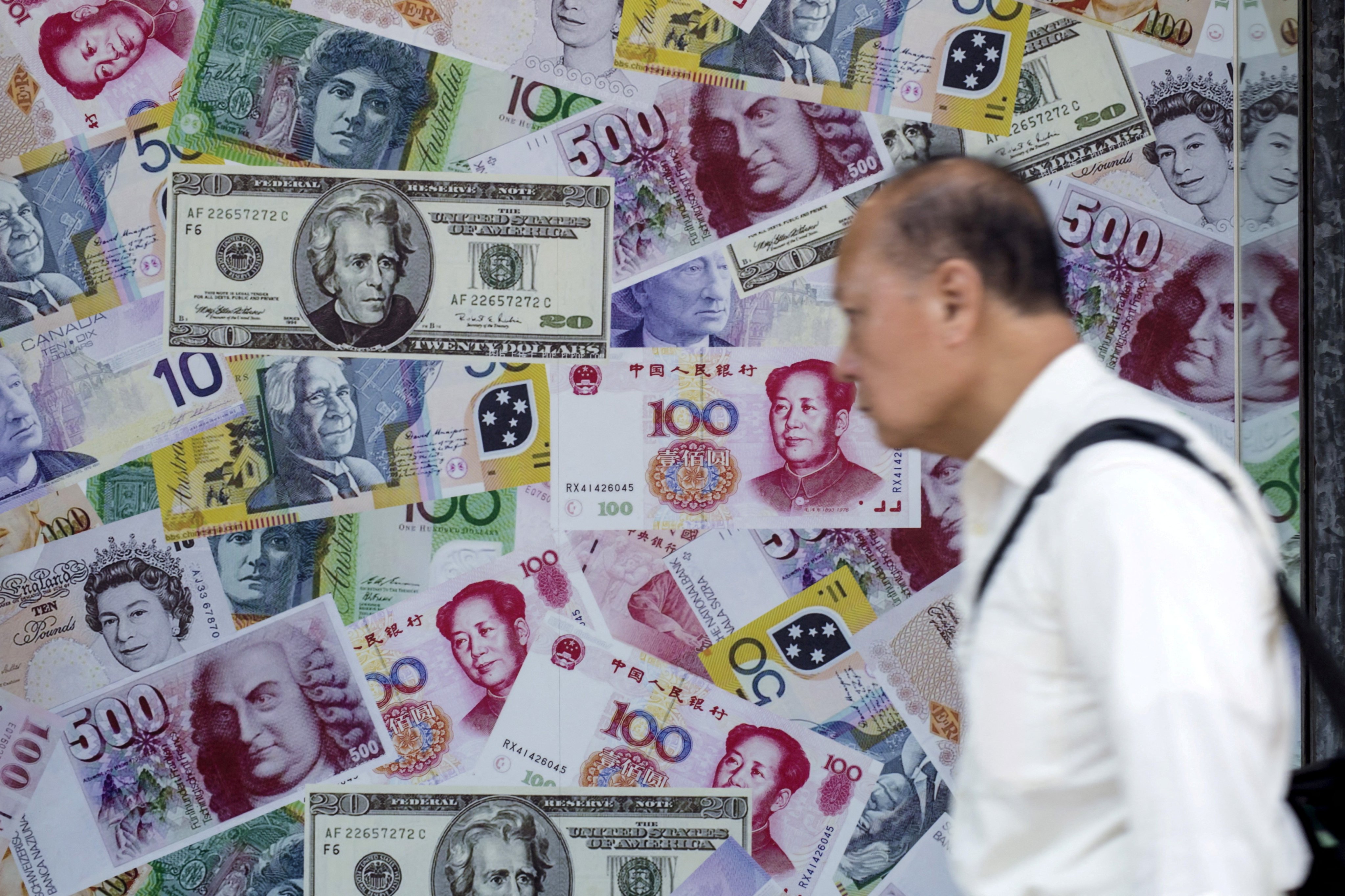 A man walks past an advertisement promoting exchange services for the yuan, US dollar and euro in Hong Kong on August 13, 2015. Photo: Reuters