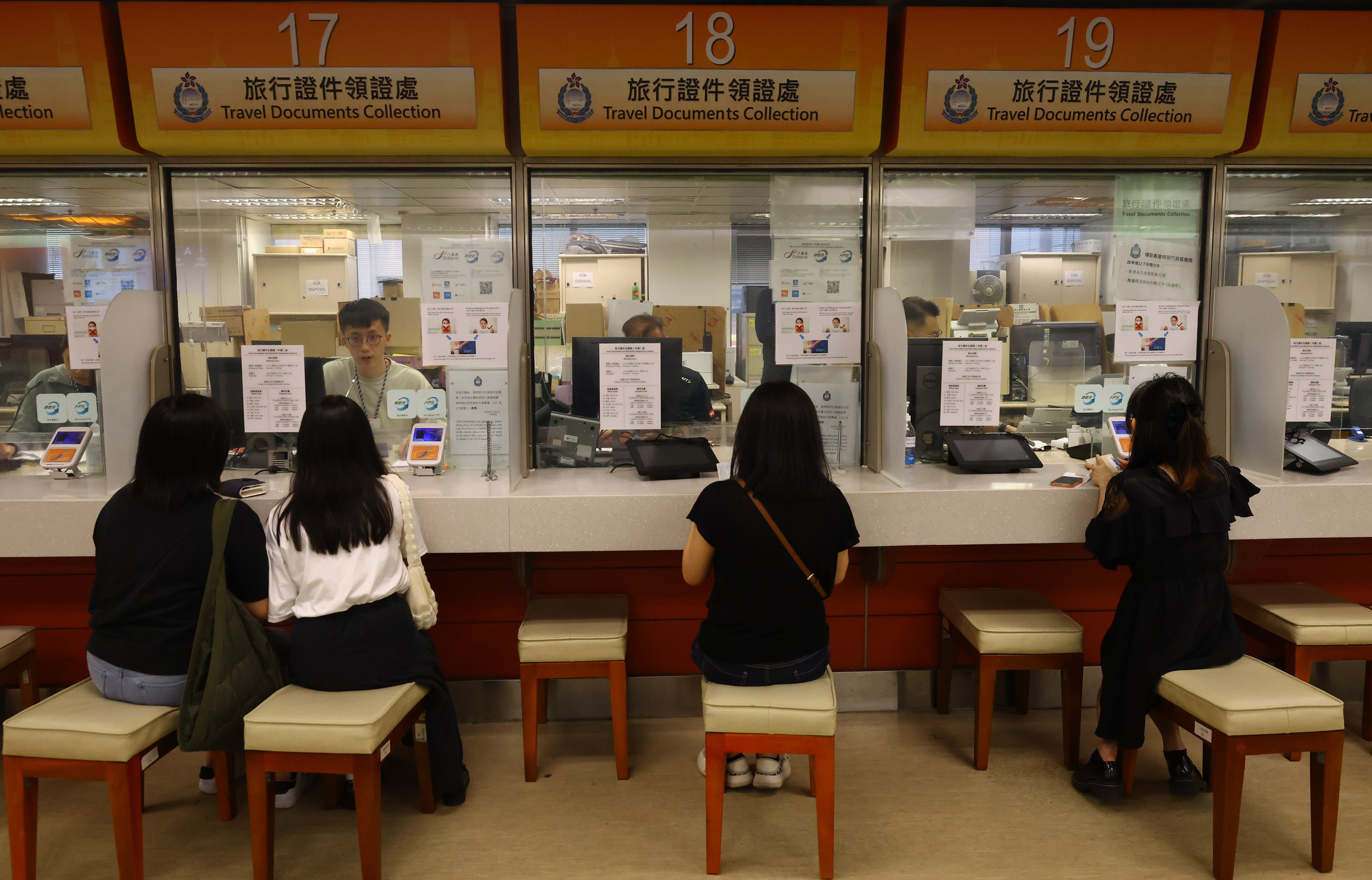 Immigration Department officers attend to residents at the office in Wan Chai. The proposal would improve the cost recovery rate, with the minimum increasing from 14 per cent to 19 per cent and the maximum reaching 100 per cent from 94 per cent. Photo: Dickson Lee