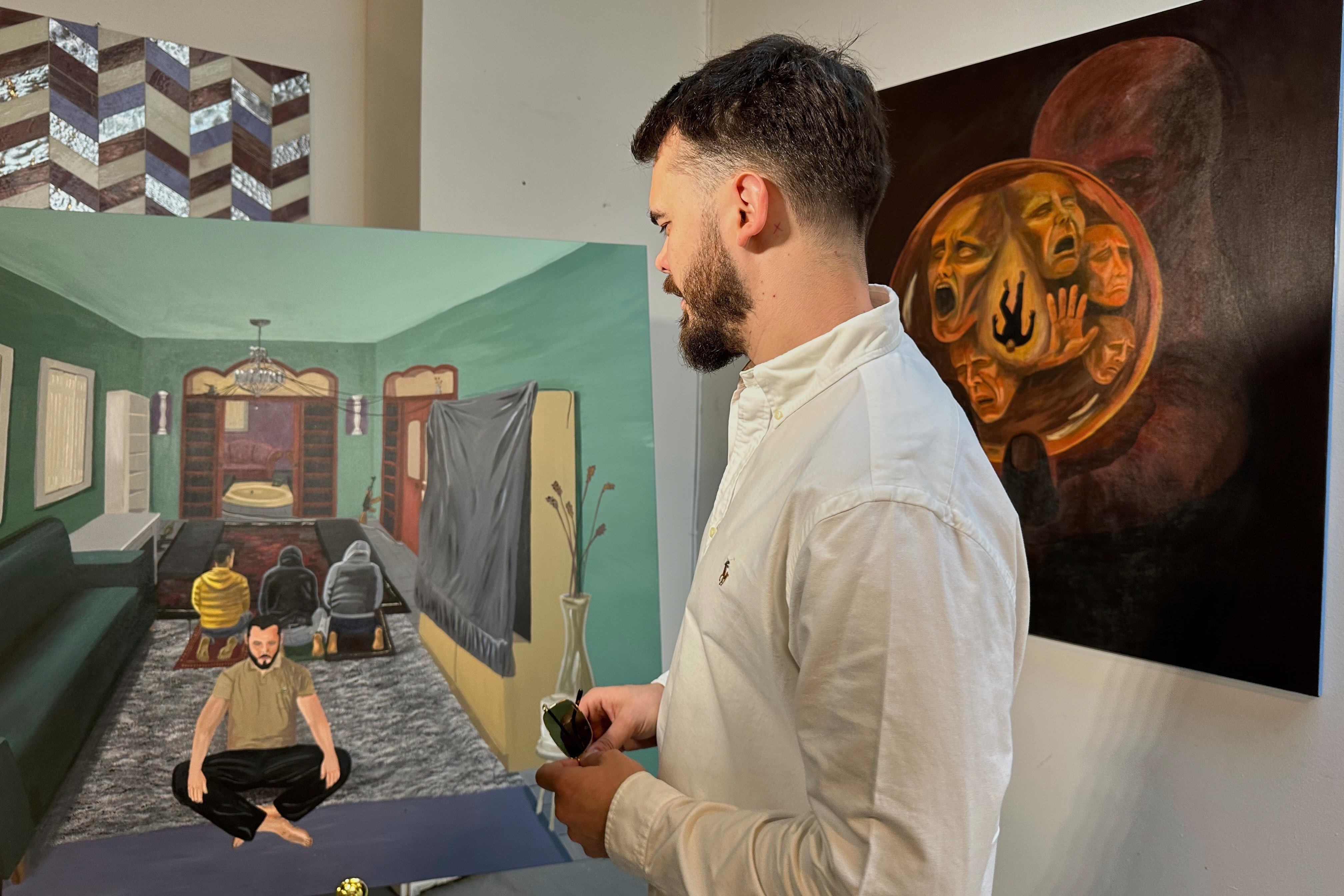 Andrei Kozlov, who was taken hostage by Hamas during the 2023 attack on Israel, looks at his painting One God. Photo: AP