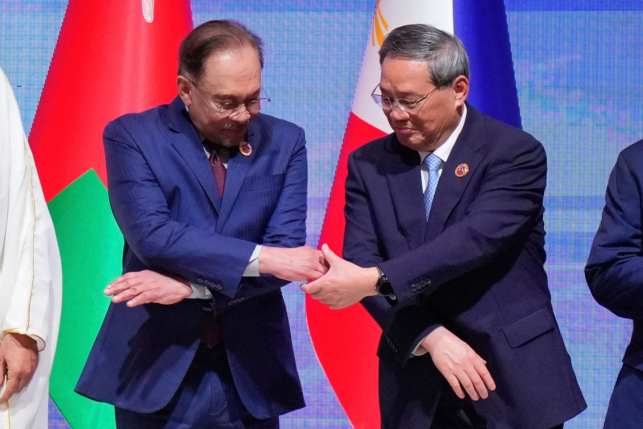 Malaysia’s Prime Minister Anwar Ibrahim, left, extends a hand to Premier Li Qiang as they pose for a group photo at the Asean-Gulf Cooperation Council-China Summit in Kuala Lumpur, Malaysia, on May 27. Photo: AP