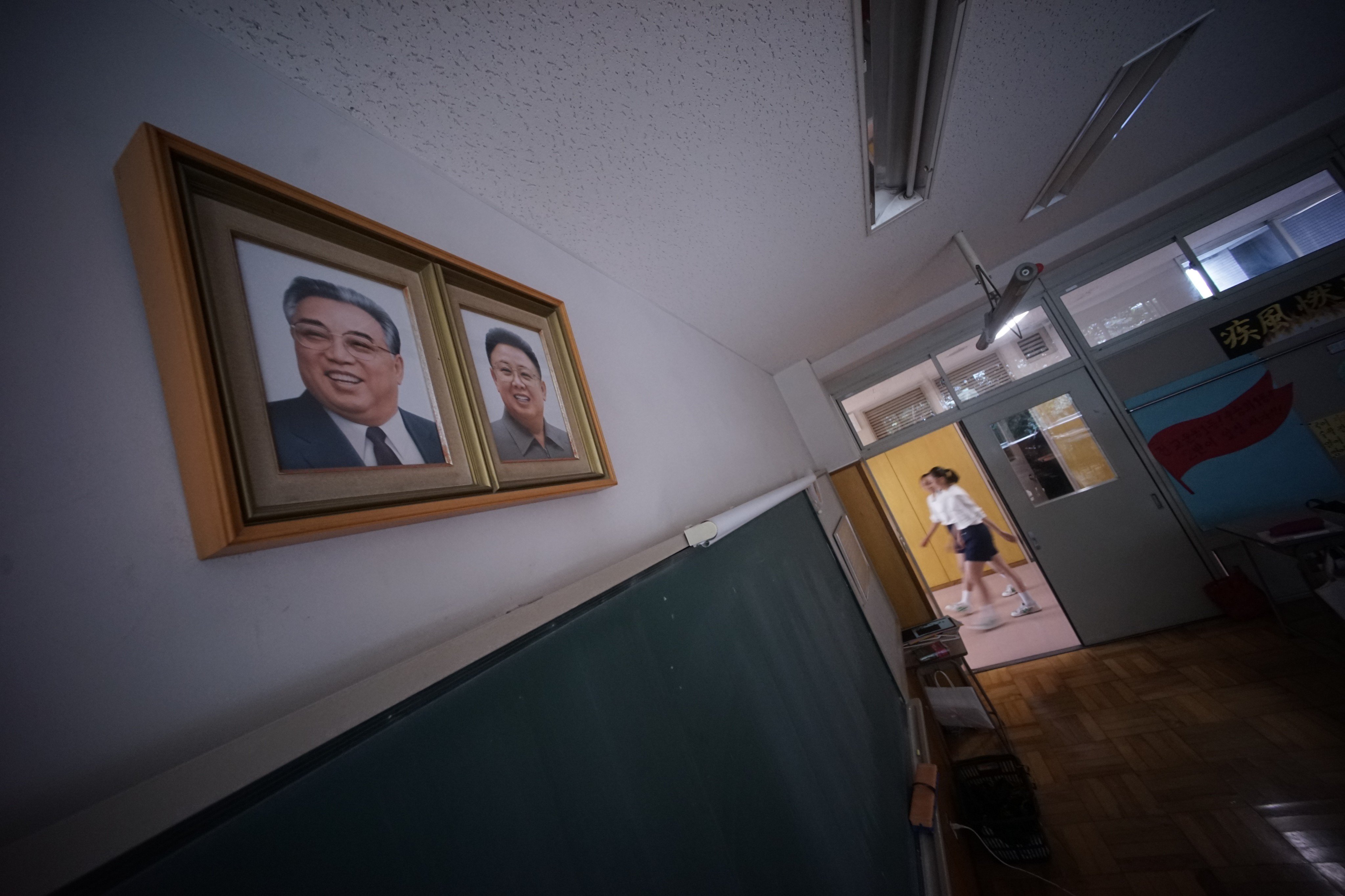 Students at a Korean school in Tokyo walk by a classroom with portraits of late North Korean leaders Kim Il-sung and Kim Jong-il on the wall. Photo: AP