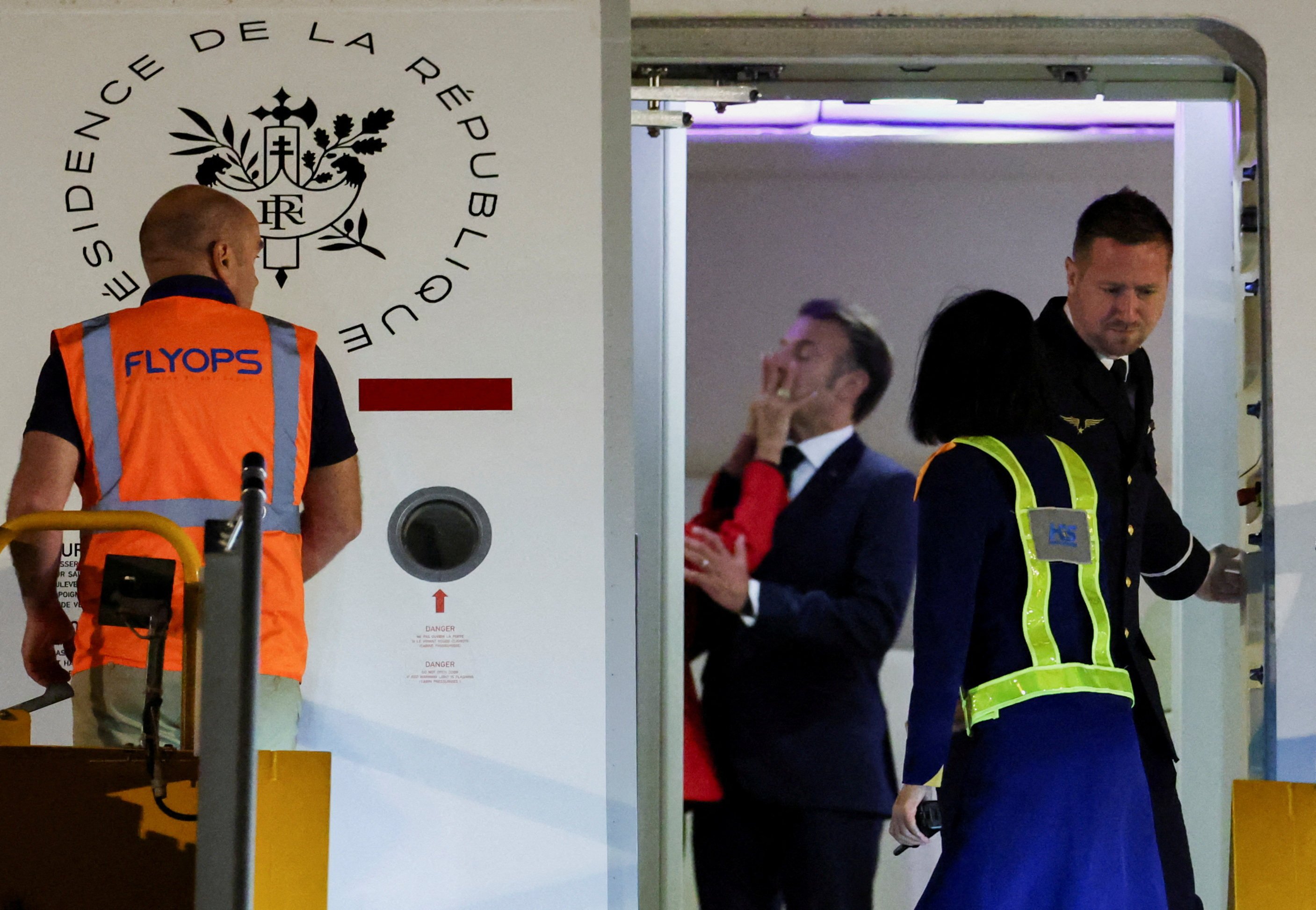 The hand of Brigitte Macron can be seen on the face of French President Emmanuel Macron as the couple arrive in Vietnam. Photo: Reuters