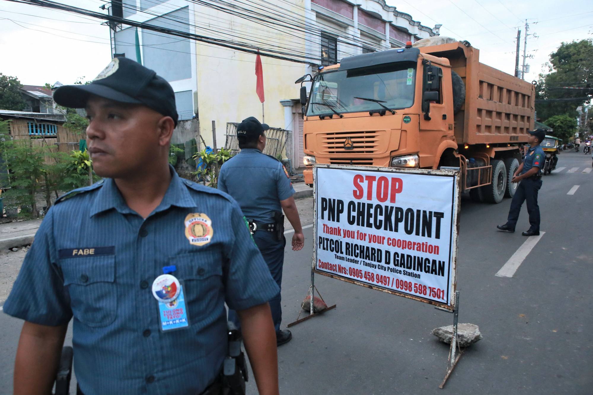 Policemen guard a checkpoint after Negros Oriental governor Roel Degamo and five others were killed by unknown gunmen. Photo: AFP Policemen guard a checkpoint after Negros Oriental governor Roel Degamo and five others were killed by unknown gunmen. Photo: AFP