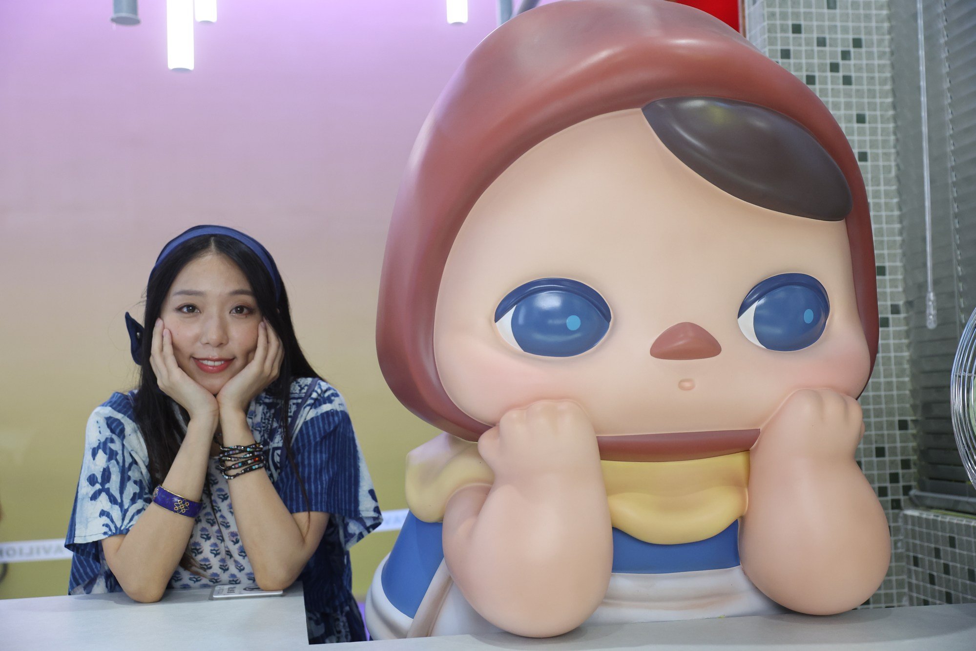 Pucky the artist poses for a picture with her namesake creation at a trade fair in Shenzhen. Photo: Edmond So Pucky the artist poses for a picture with her namesake creation at a trade fair in Shenzhen. Photo: Edmond So
