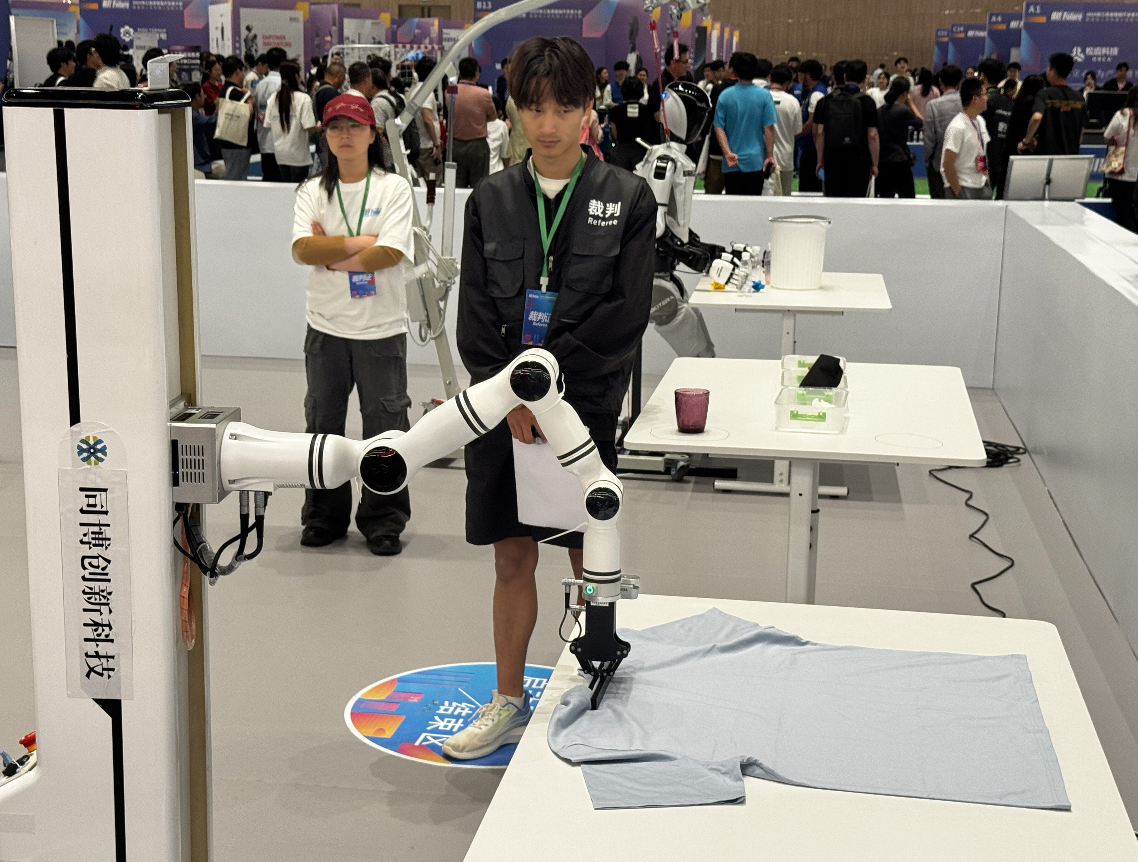 A controlled robotic arm attempts to fold clothes at an event in Shanghai on Thursday. Photo: Wency Chen